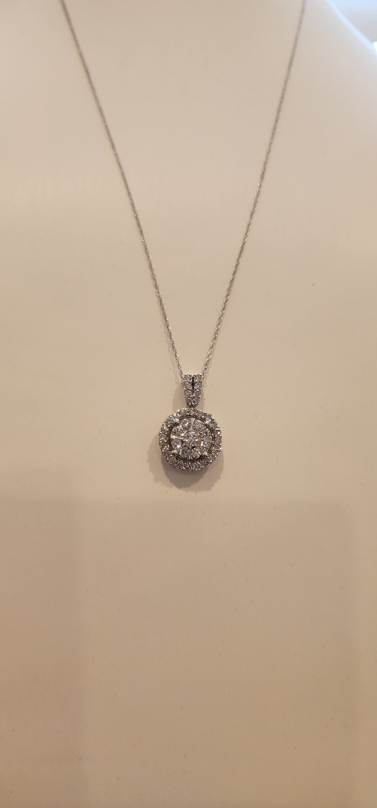 Silver necklace with a decorative pendant on a beige surface