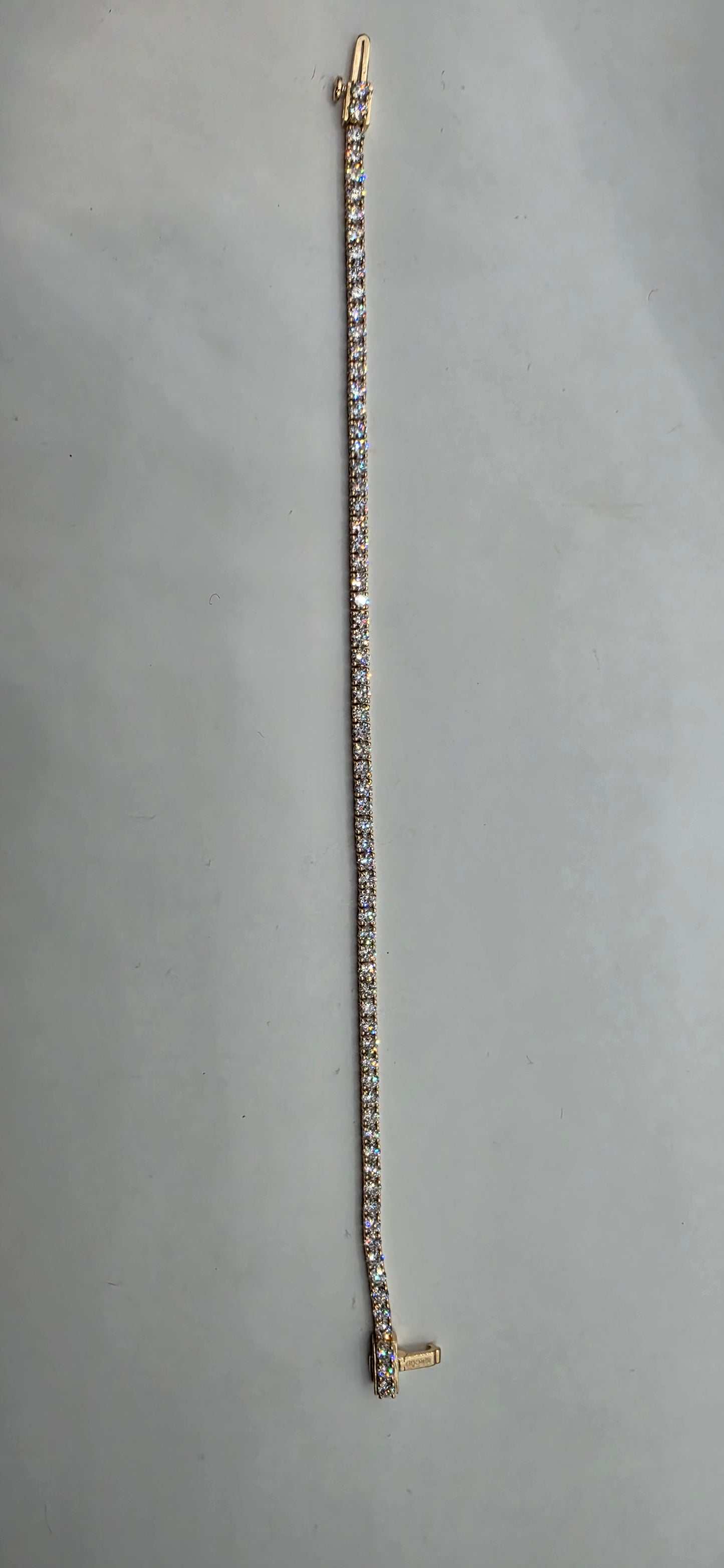 Silver bracelet with gold clasp on a gray background