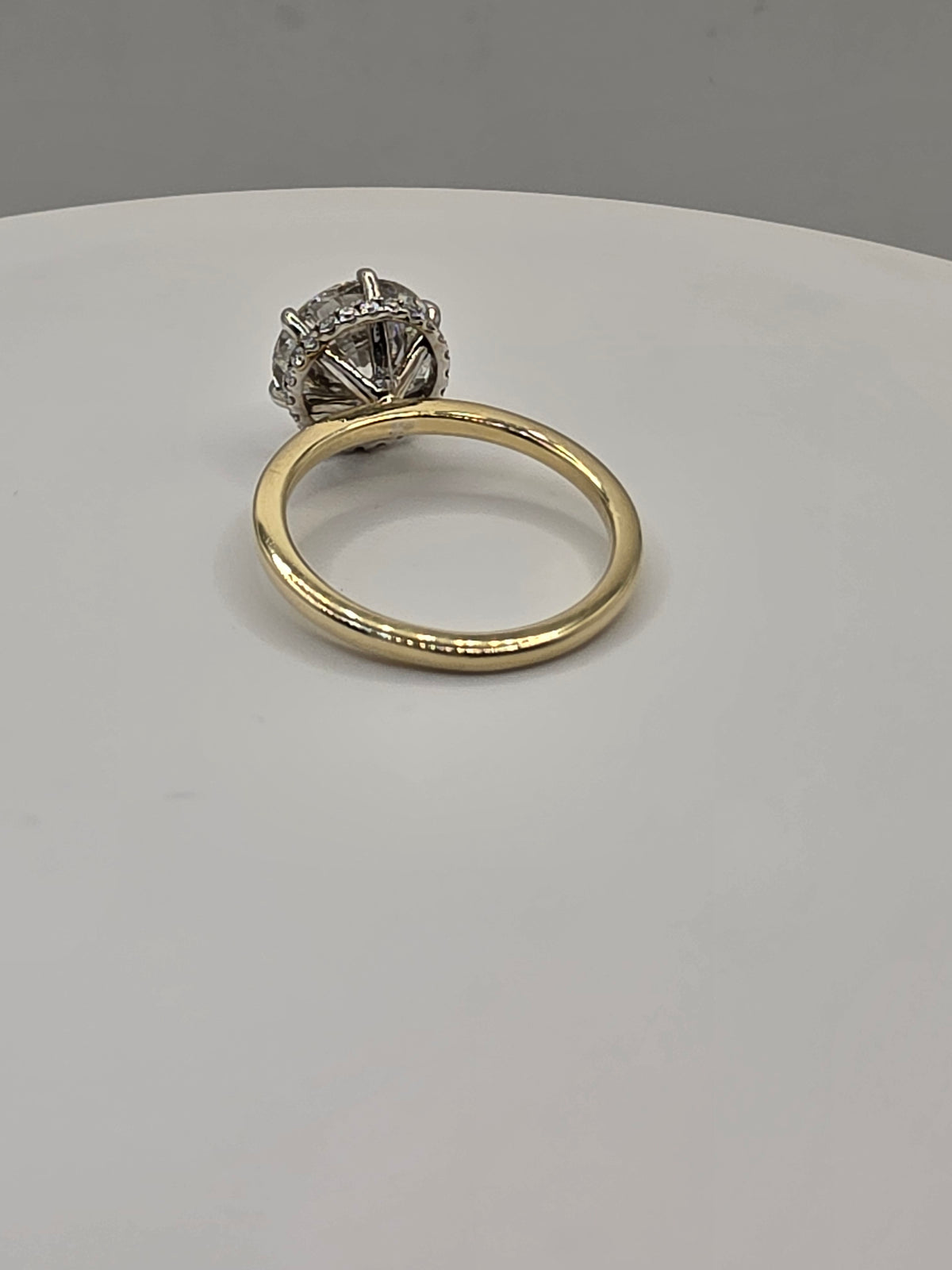 Round diamond ring with yellow gold on a white background