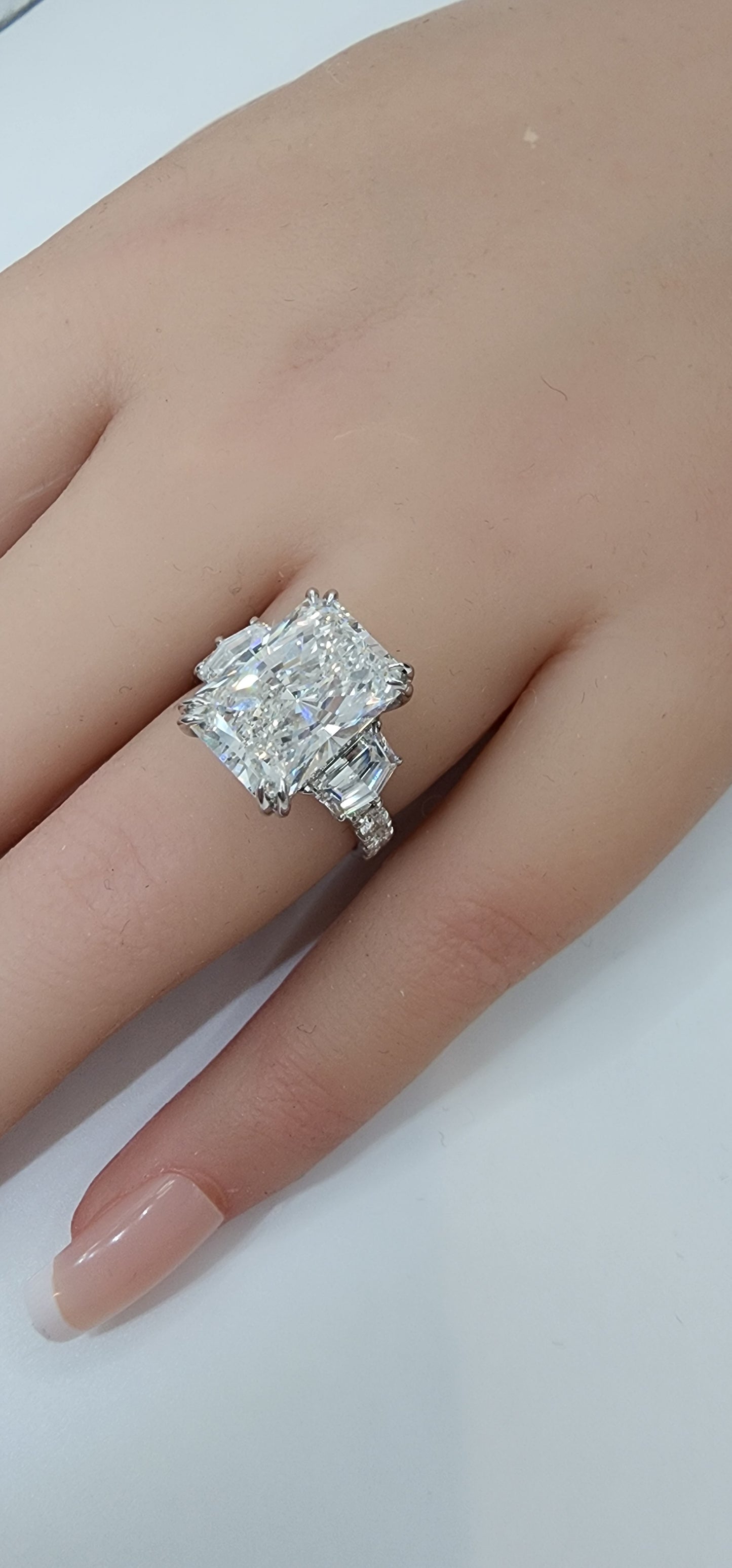 Diamond ring on a finger against a white background
