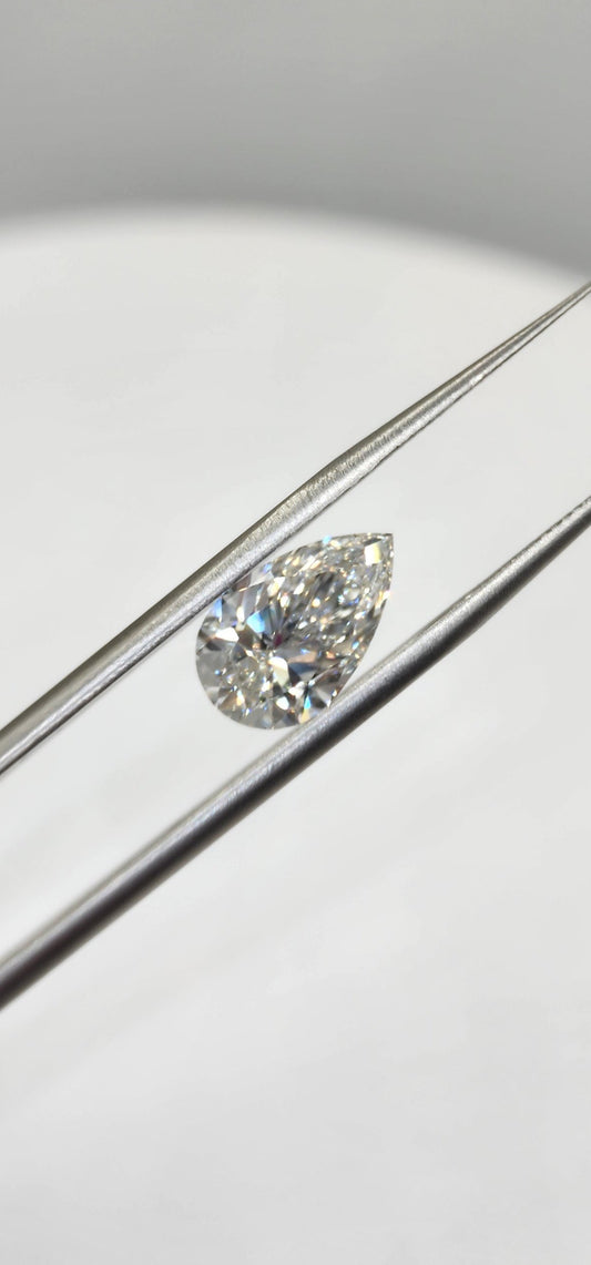 Pear-shaped diamond on a silver ring with a light gray background