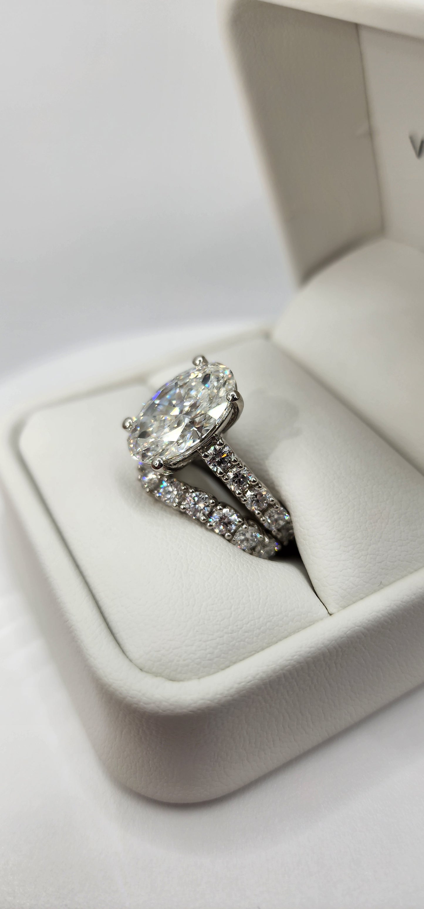 "The Marisol" is a 5 Carat Oval Lab Gown Diamond, F/VS1 set in 14k White Gold with Accent diamonds and a contoured wedding band