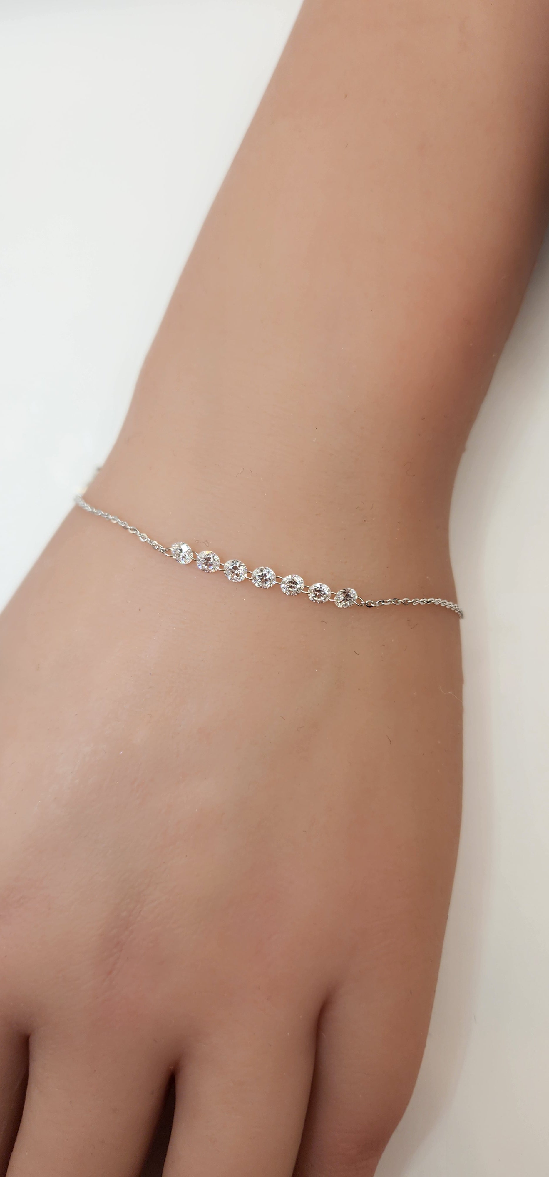 White Gold and Diamond bracelet on a wrist against a white background