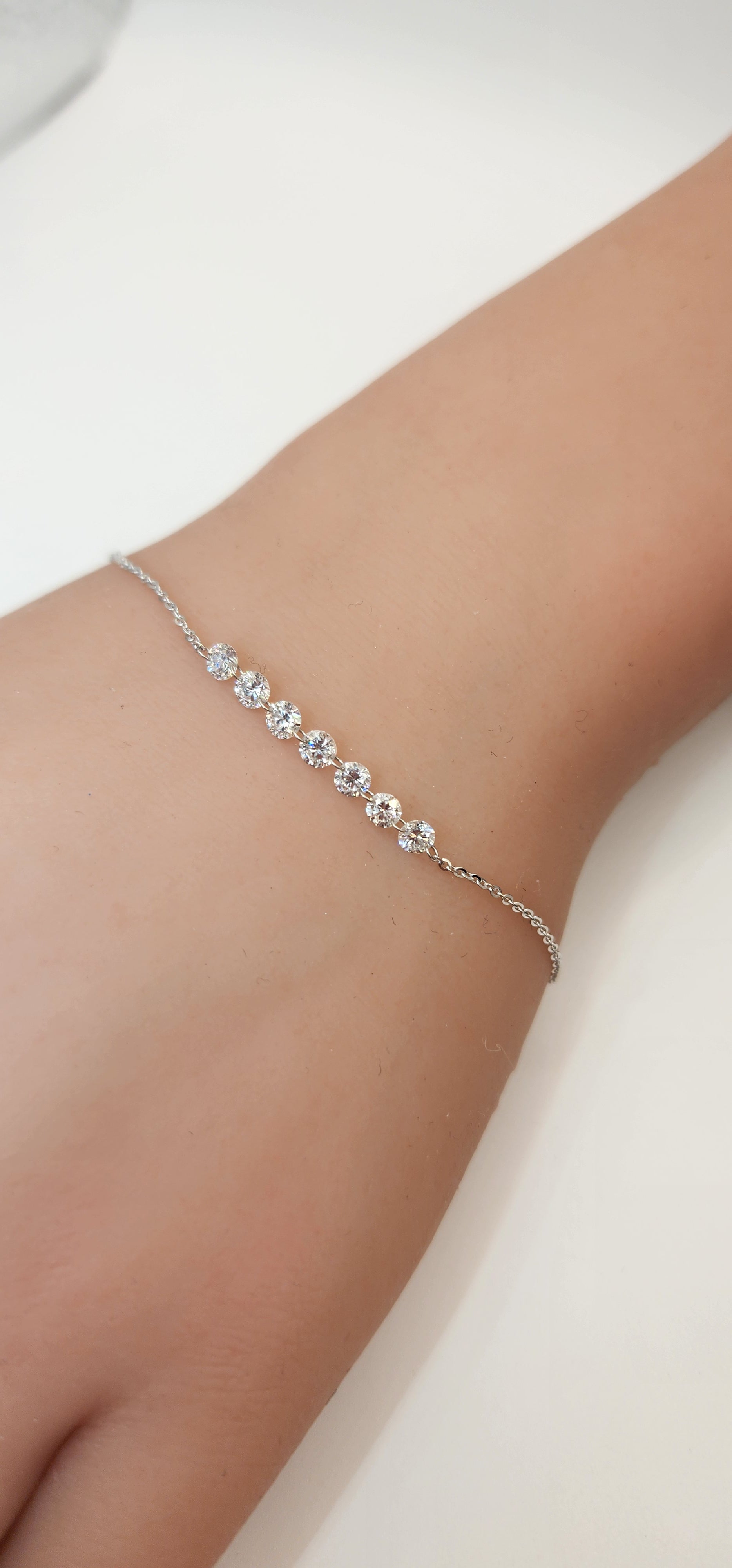 White Gold and Diamond bracelet on a wrist against a white background