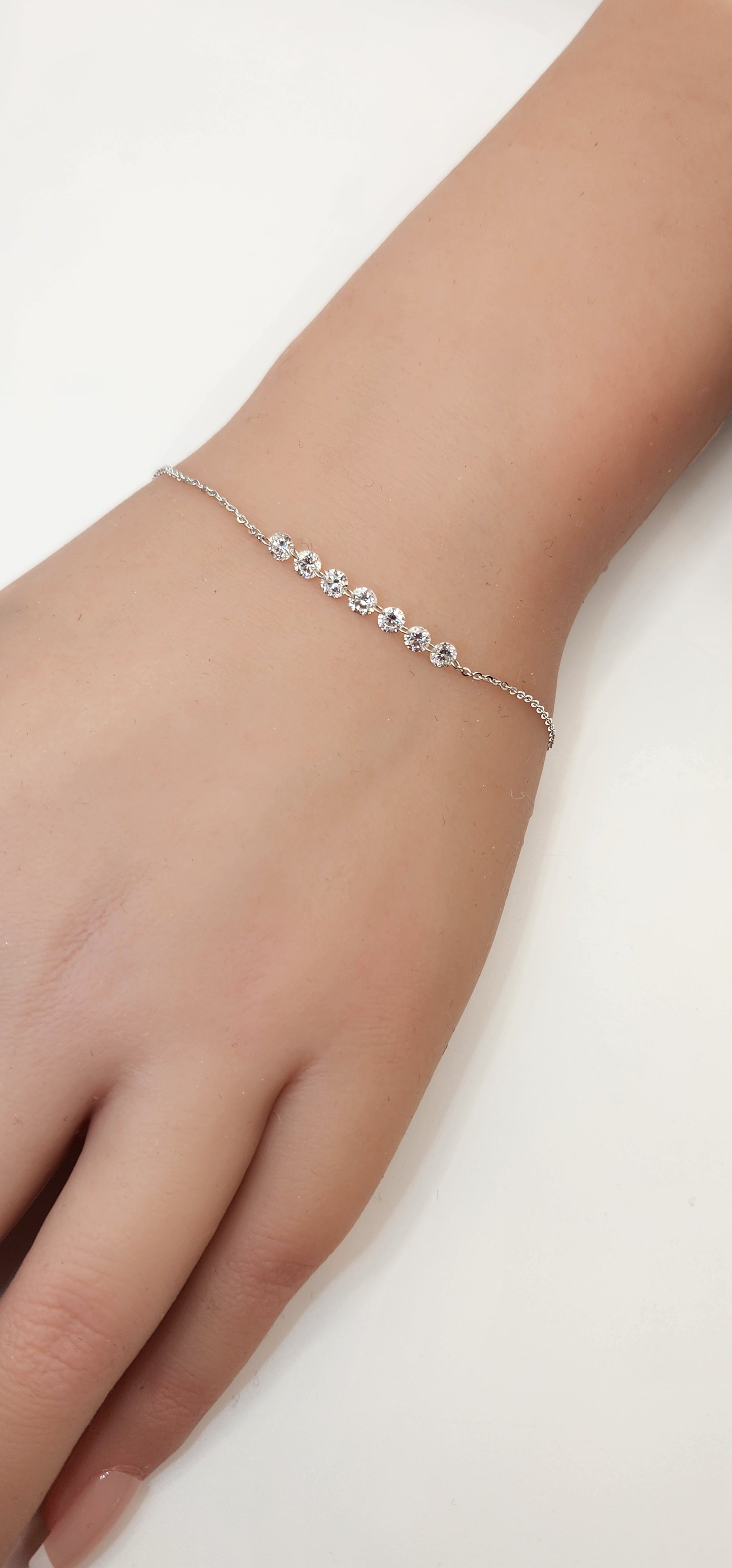 White Gold and Diamond bracelet on a wrist against a white background
