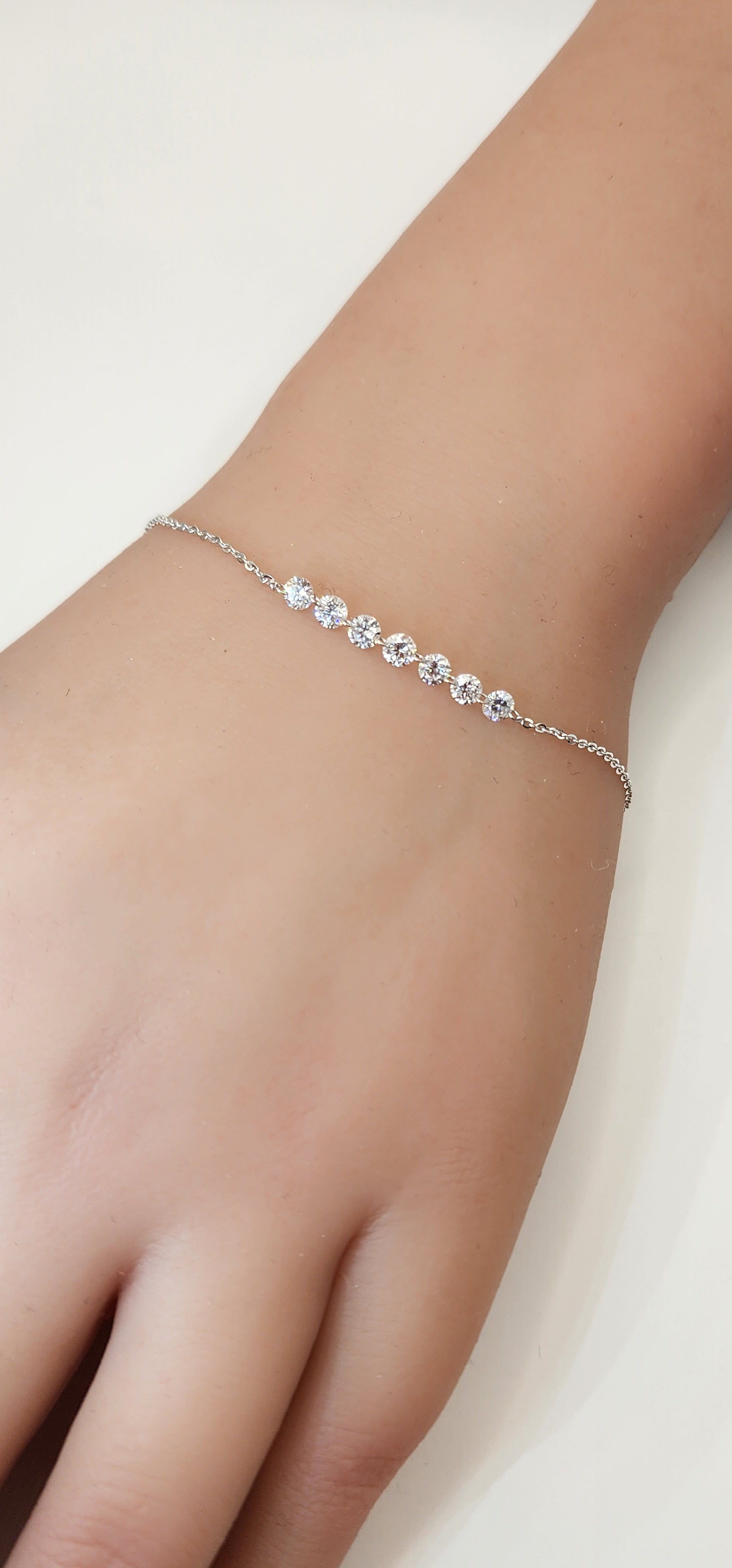 White Gold and Diamond bracelet on a wrist against a white background