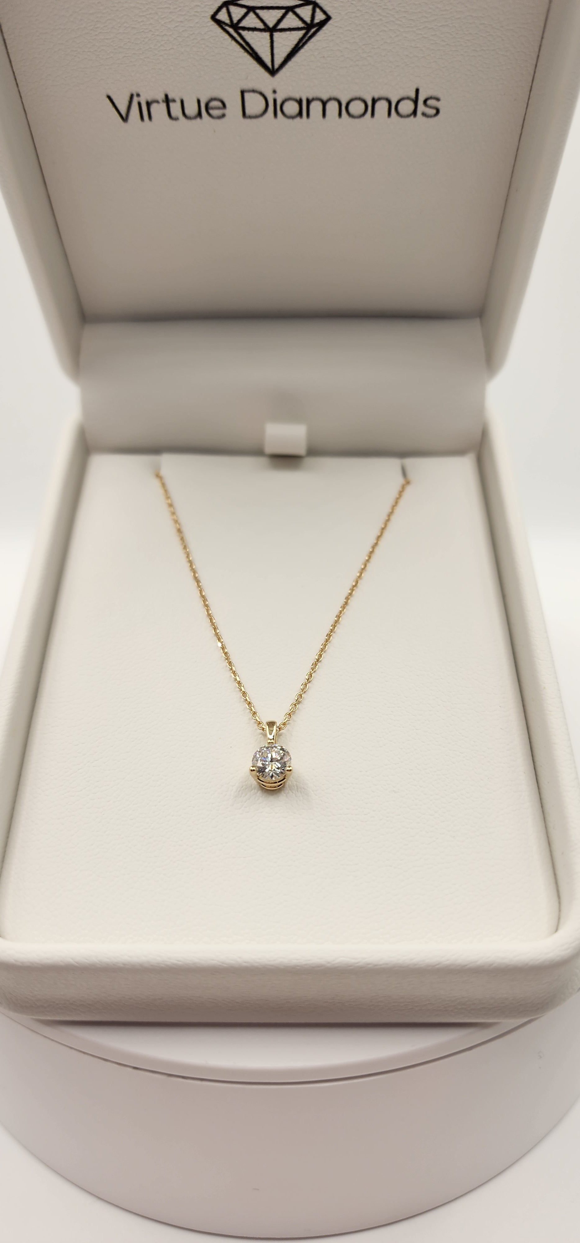 Gold necklace in a 'Virtue Diamonds' box on a white background