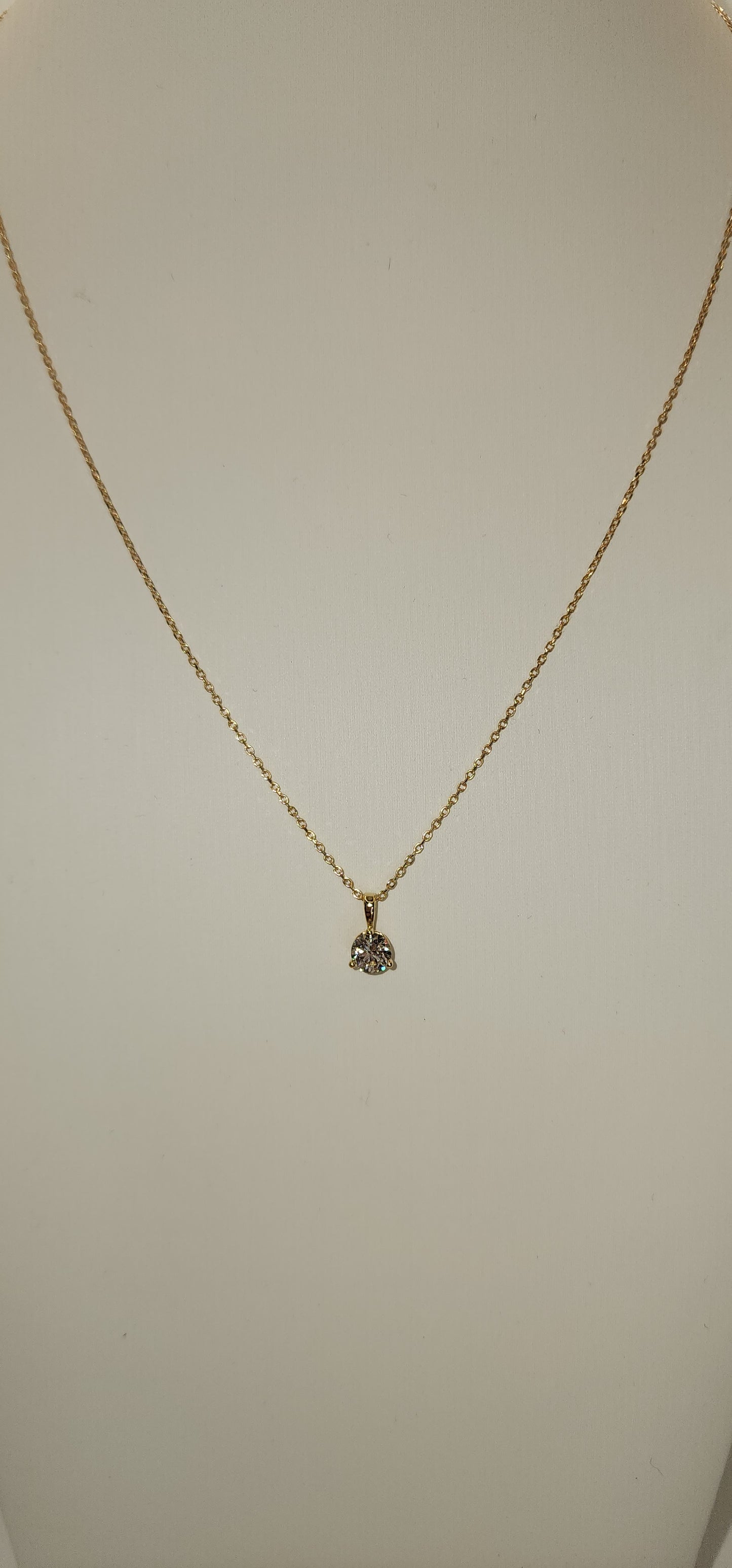 Gold necklace with a small pendant on a light gray background