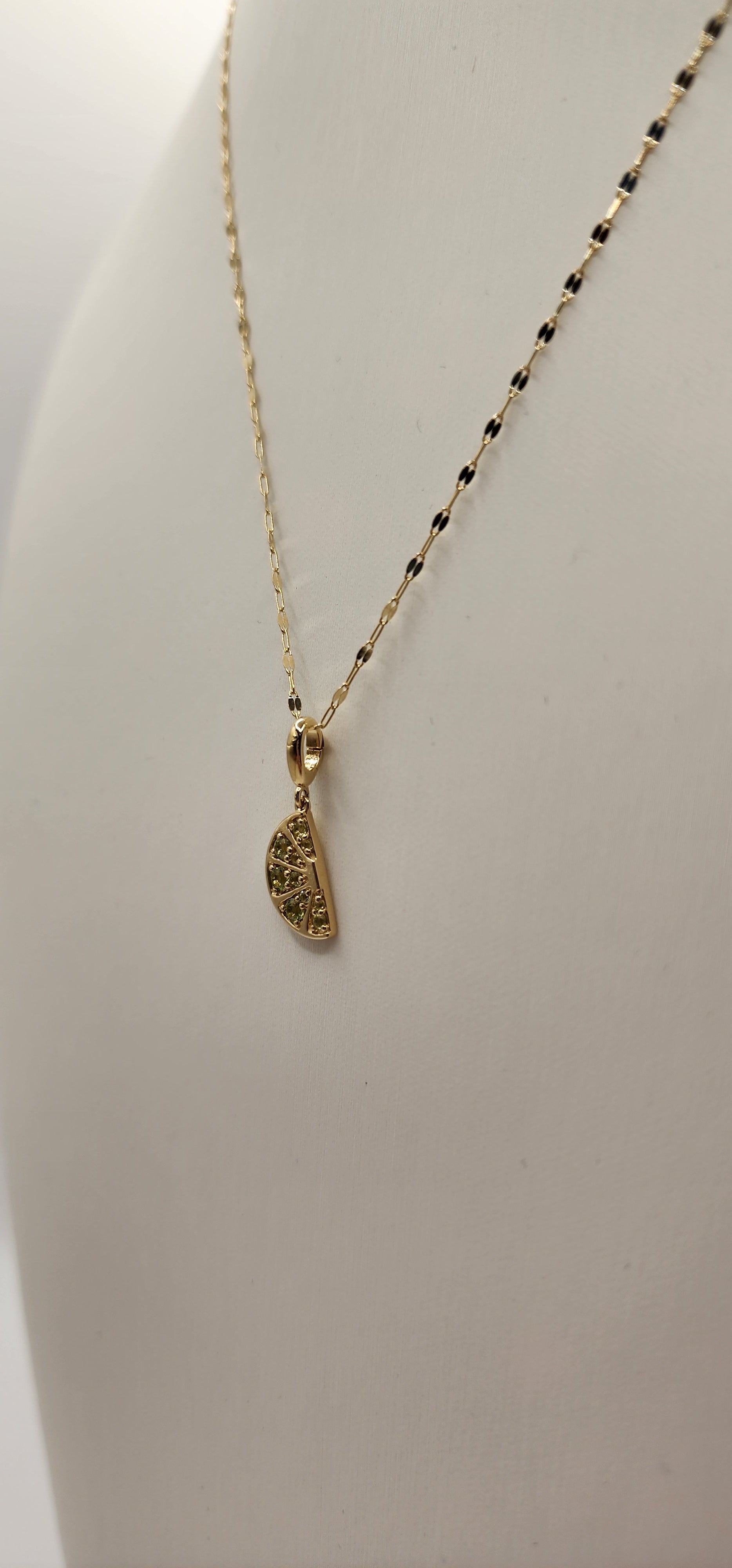 Gold necklace with a pendant on a light gray background