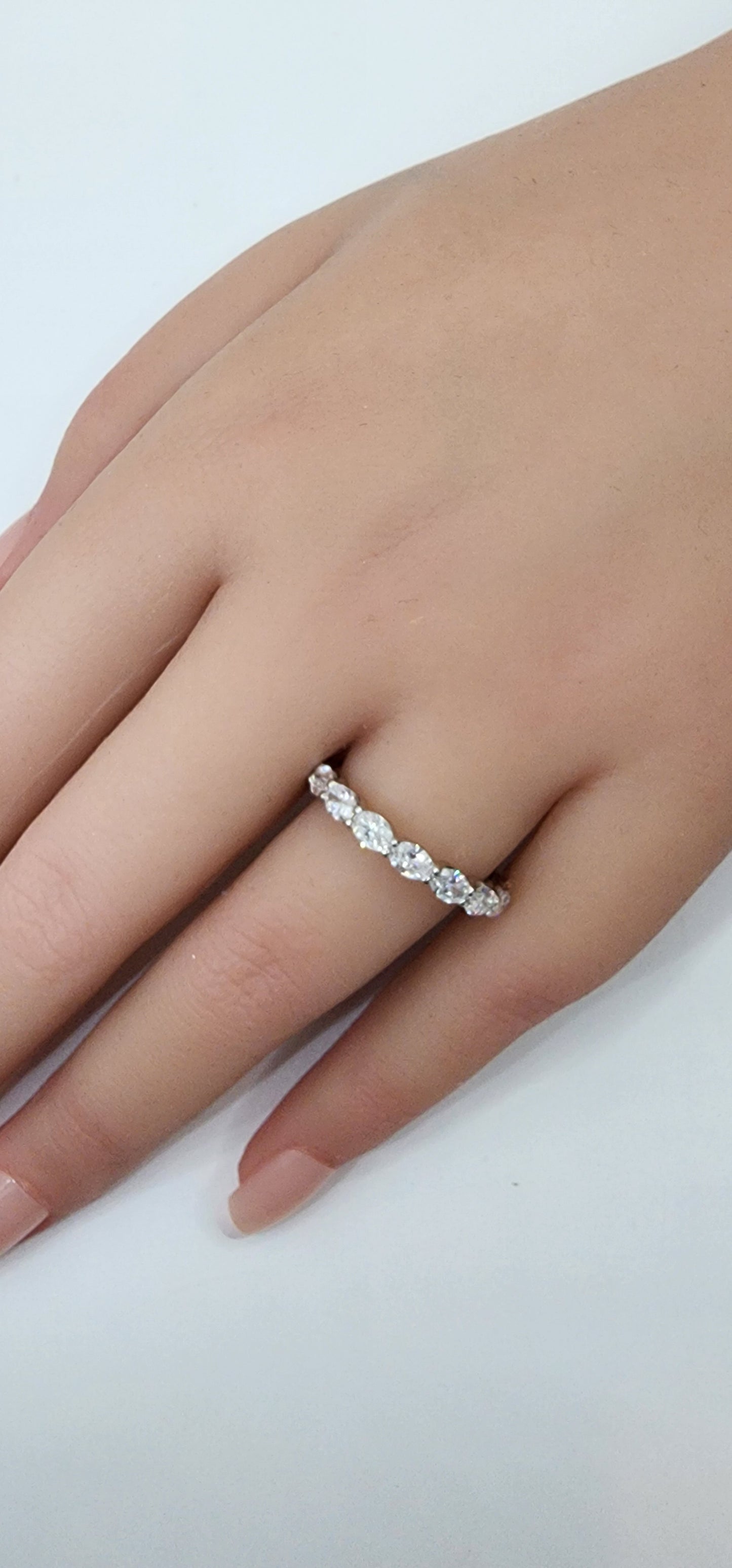 Silver ring on a person's finger against a white background