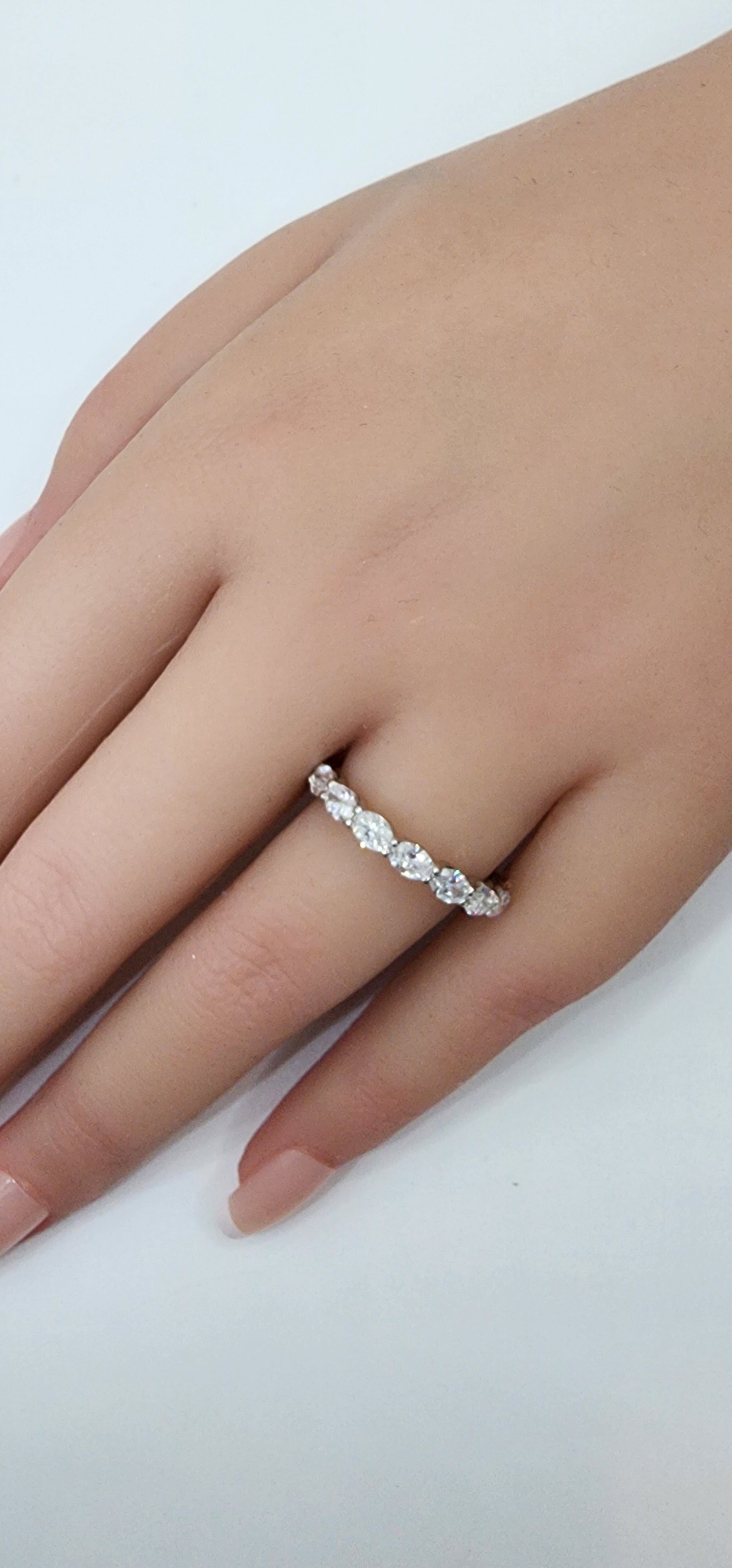 Silver ring on a person's finger against a white background