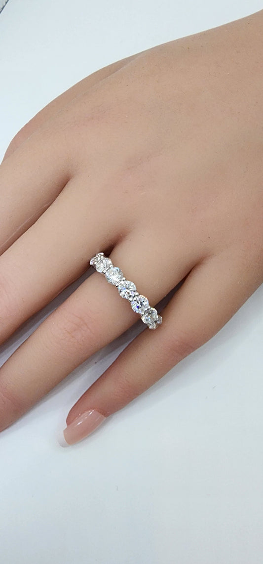 Diamond ring on a person's finger against a white background
