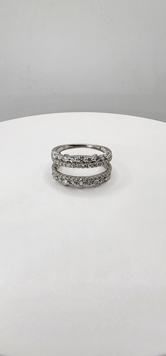 White Gold  ring with embedded stones on a white stand against a gray background