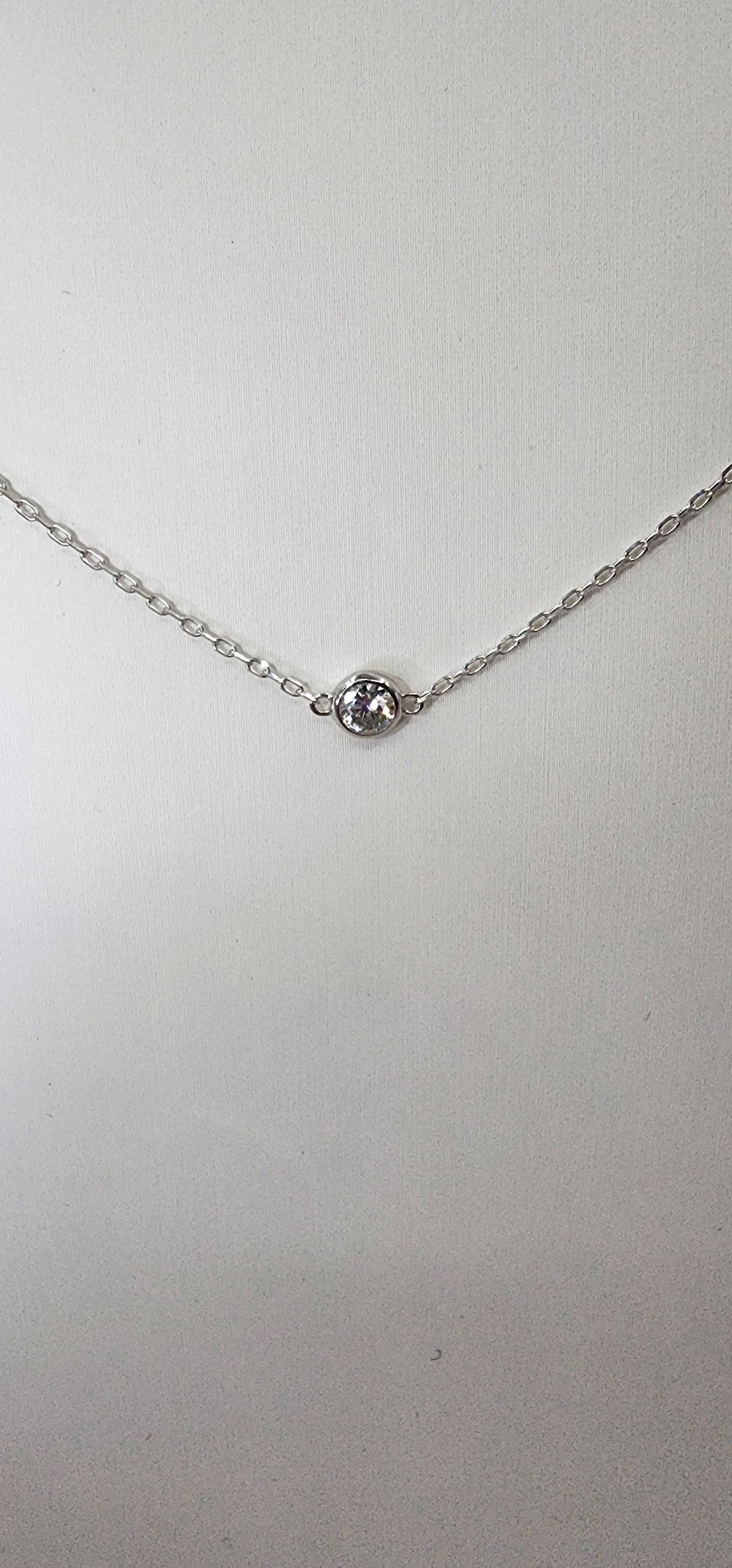 White gold and diamond necklace against white background
