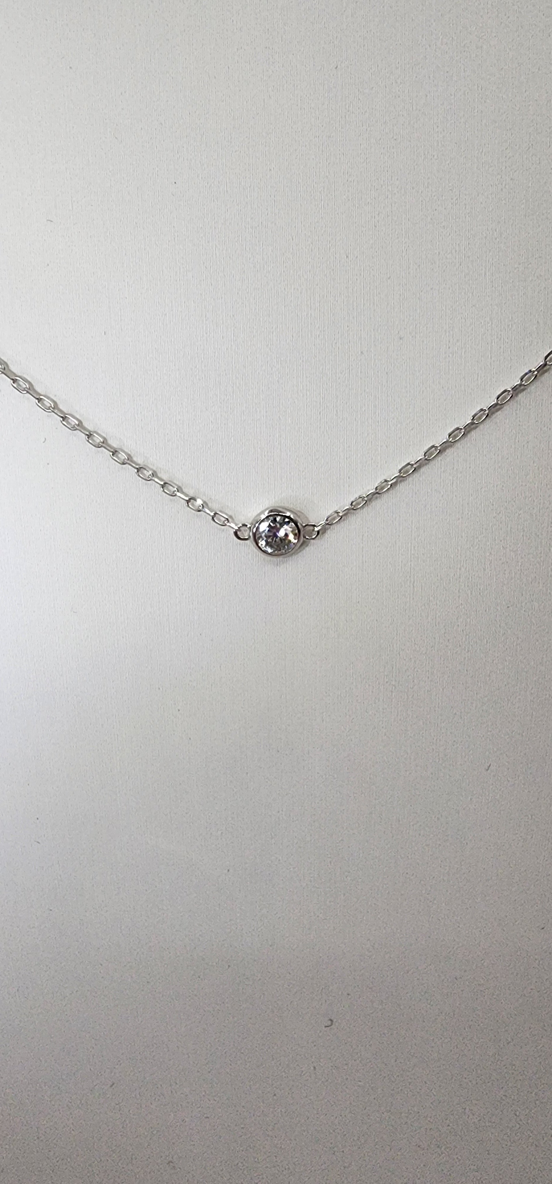 White gold and diamond necklace against white background
