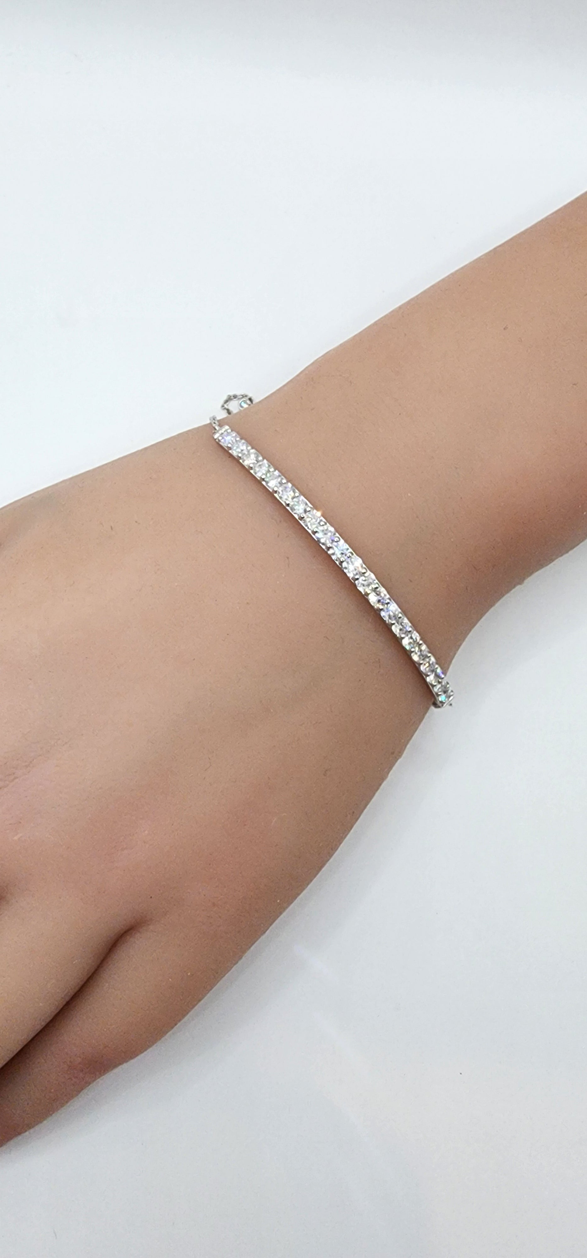White Gold and Diamond bracelet on a persons wrist in front of a white background