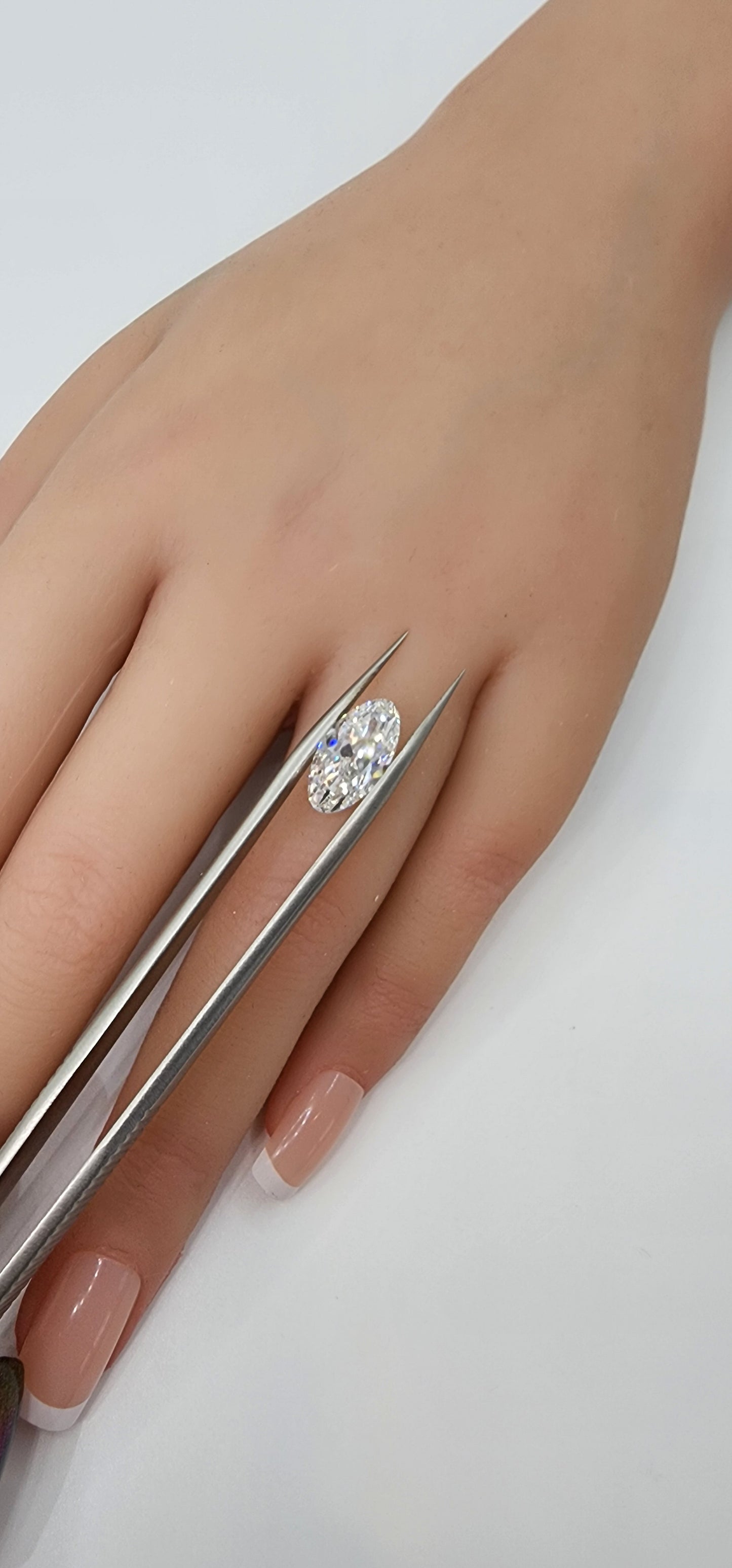 Hand wearing a silver ring with a diamond on a white background
