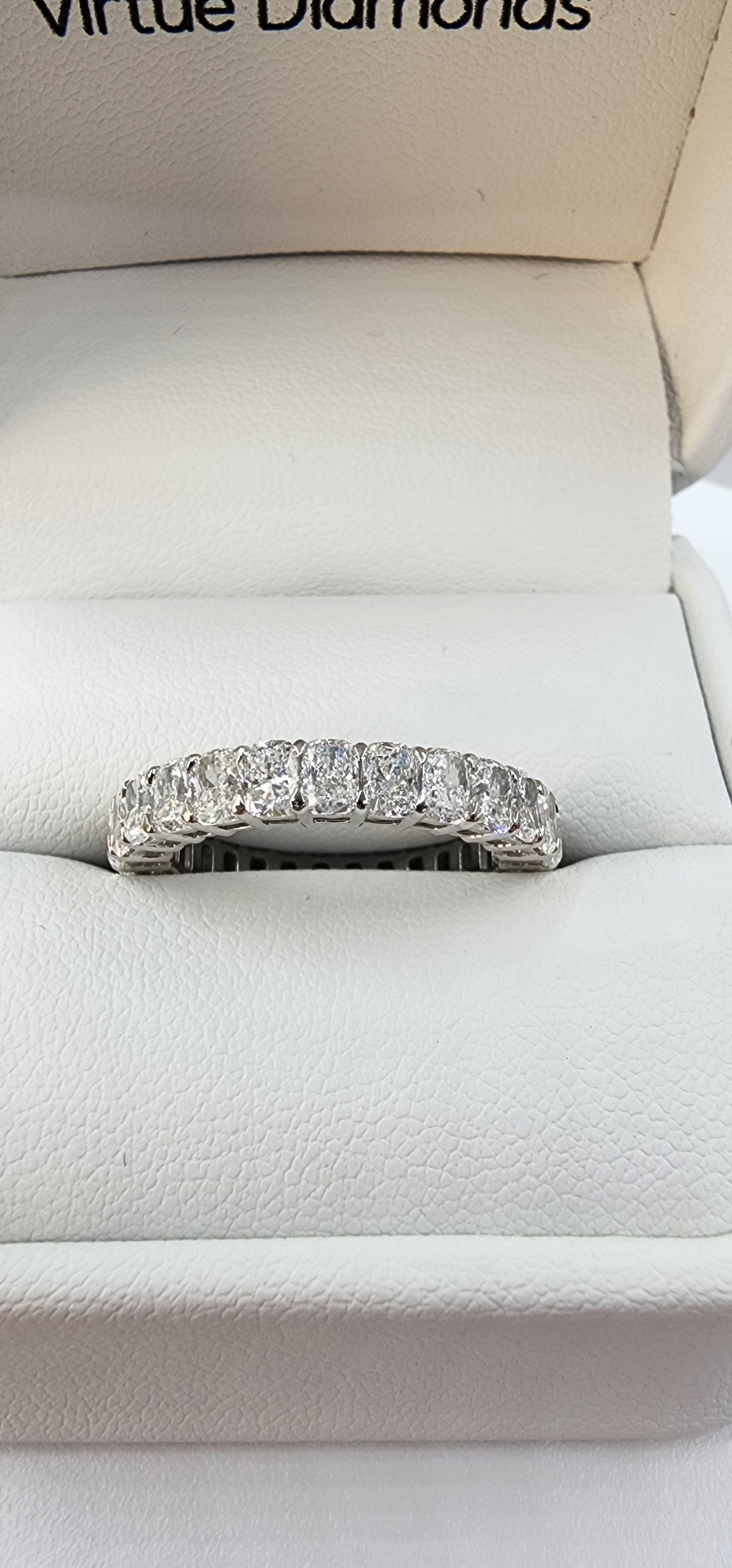 Diamond ring on a white cushion with 'Virtue Diamonds' branding.
