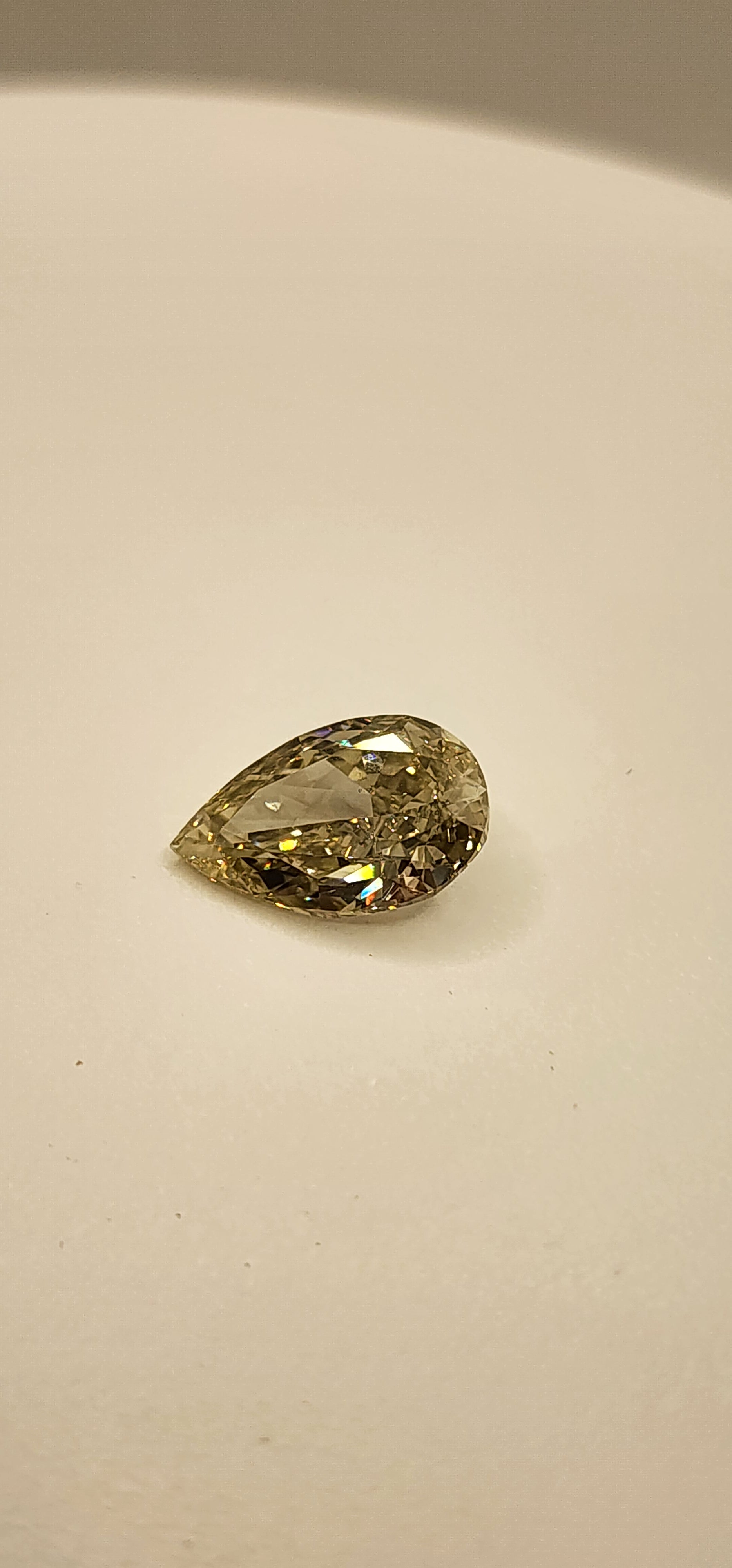 Yellow diamond on white display in front of grey background
