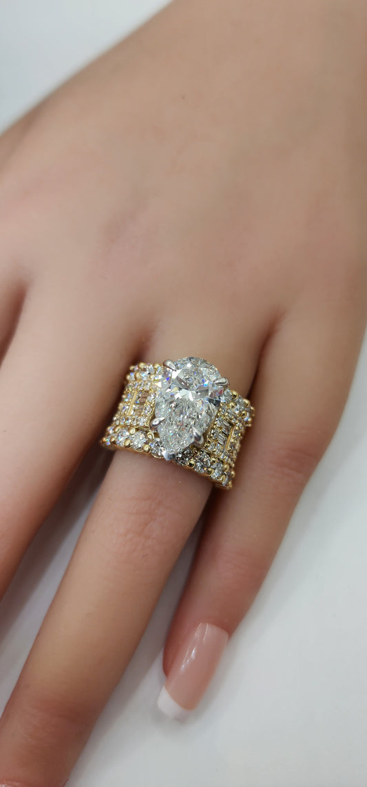 pear diamond ring on a hand against a white background