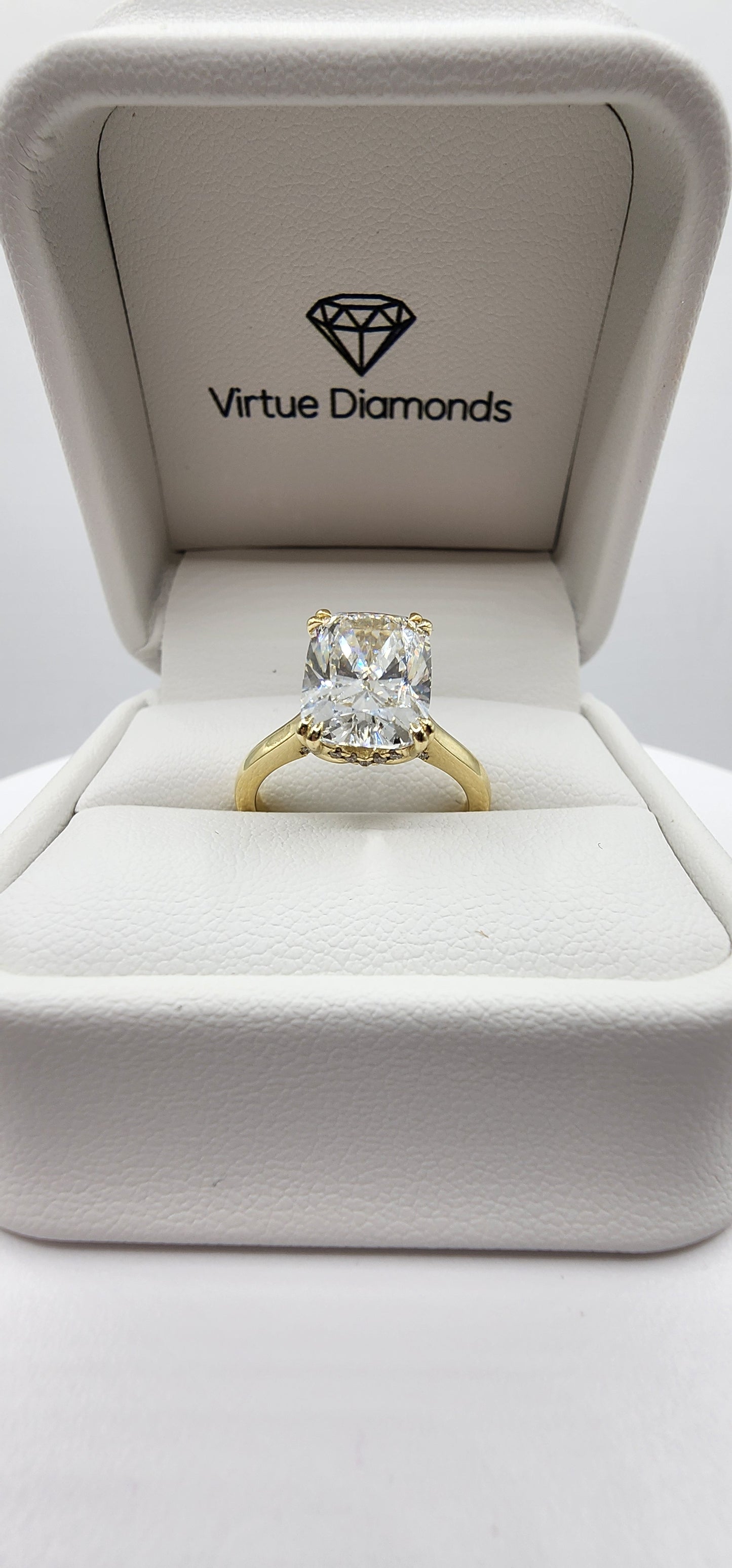Gold diamond ring in a box with 'Virtue Diamonds' branding.