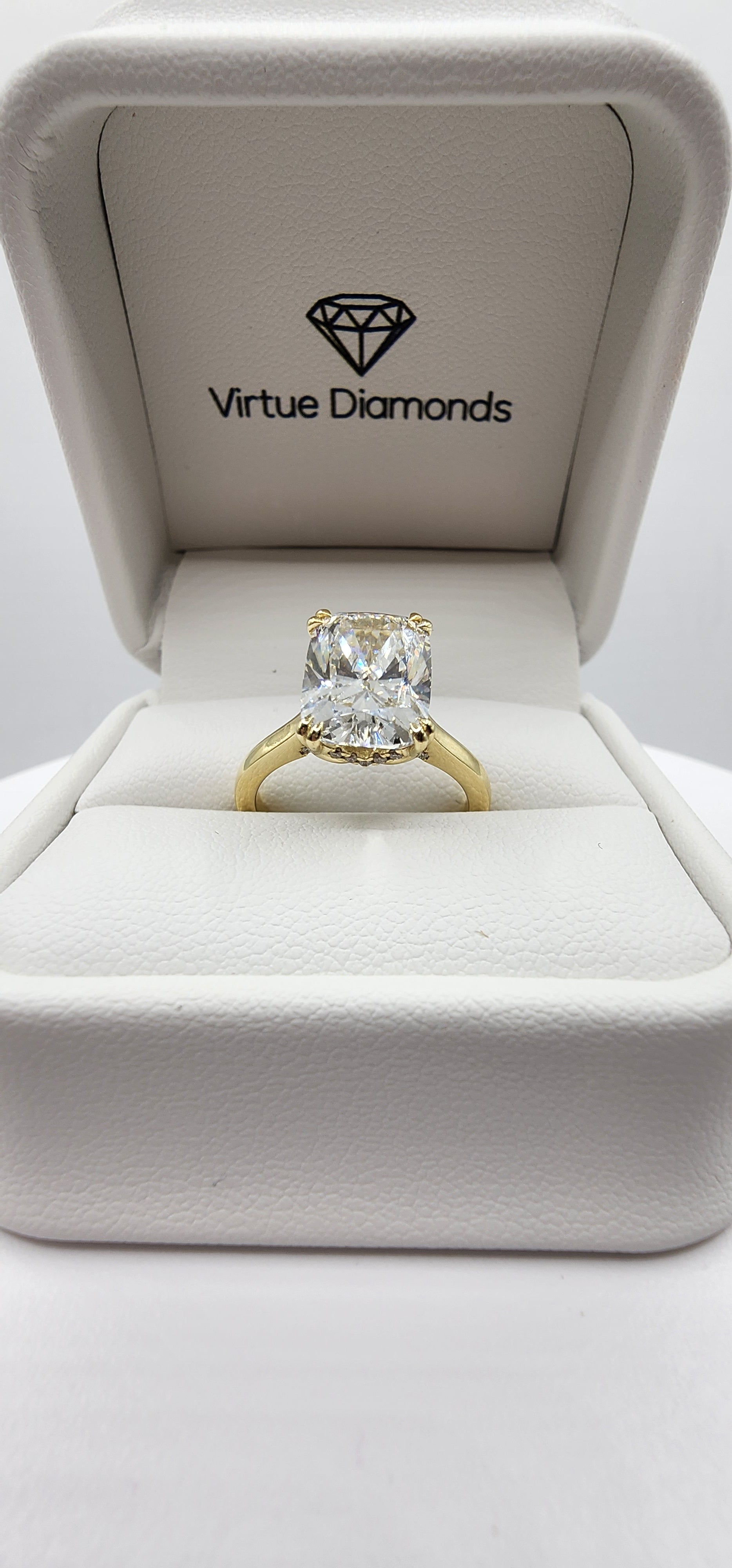 Gold diamond ring in a box with 'Virtue Diamonds' branding.