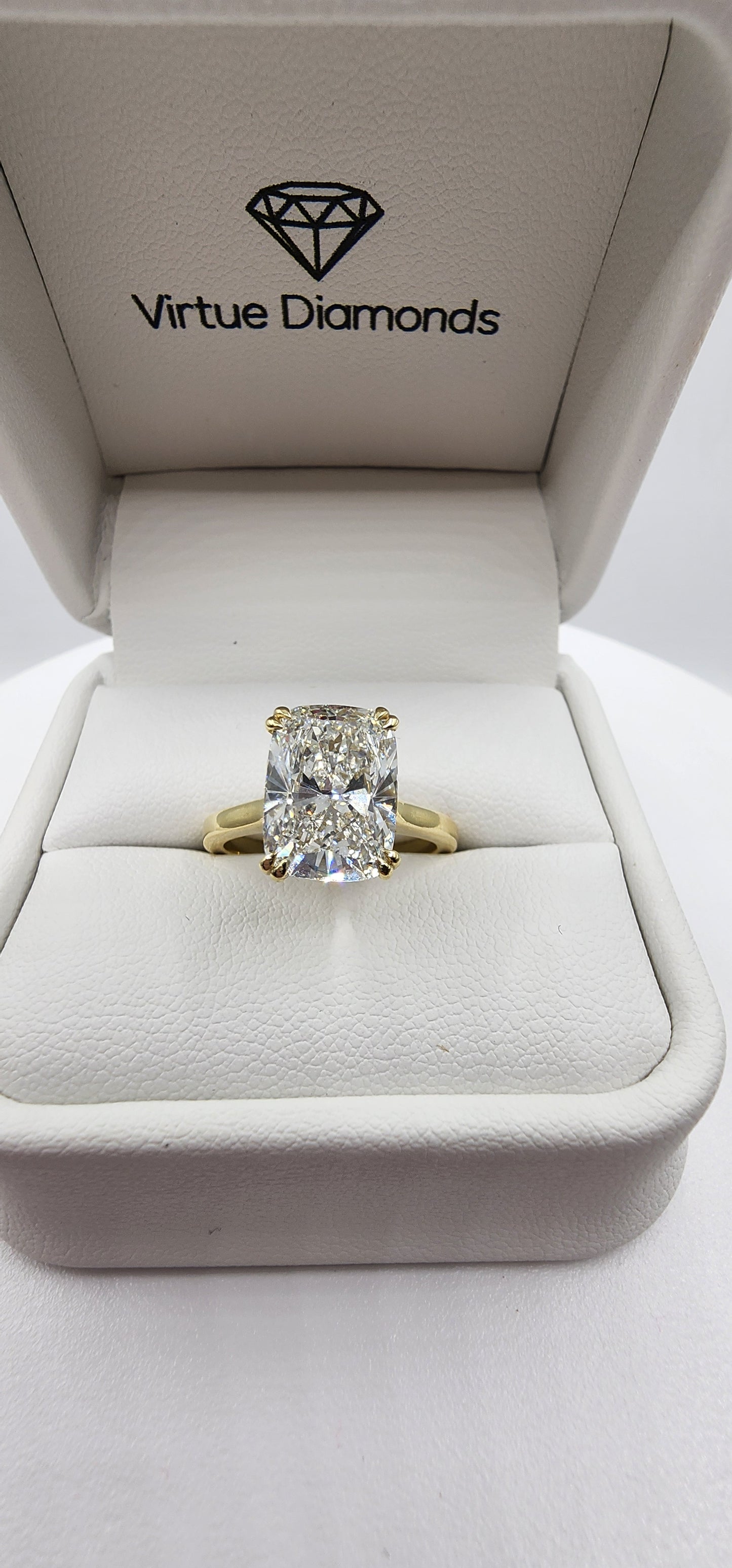 Diamond ring in a 'Virtue Diamonds' box on a white background