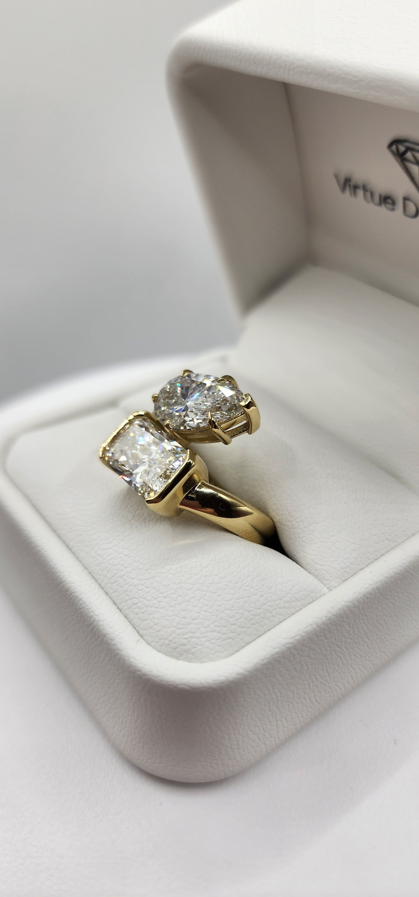 Gold and diamond ring in a white ring box on a white display