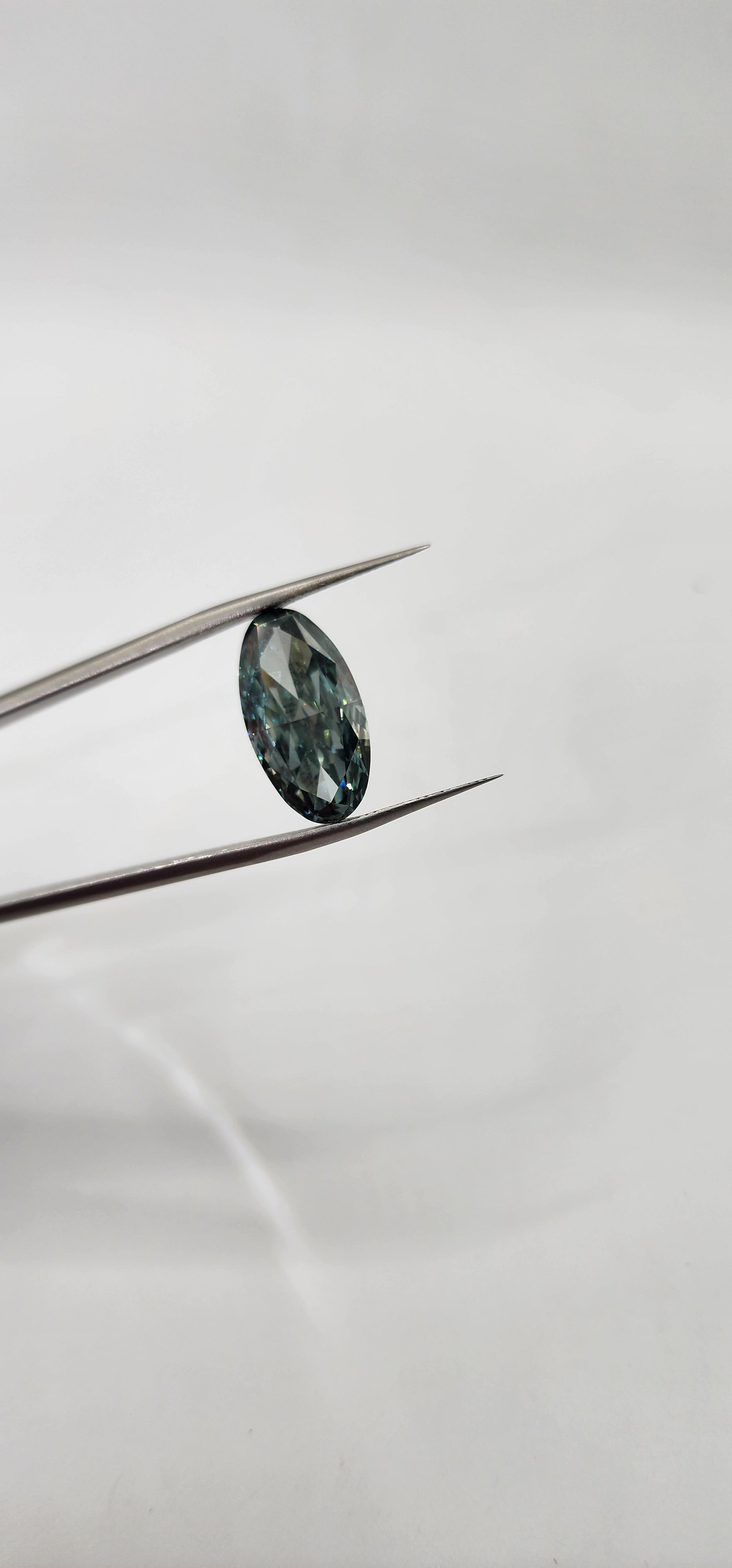 Diamond on a thin metal rod against a light gray background