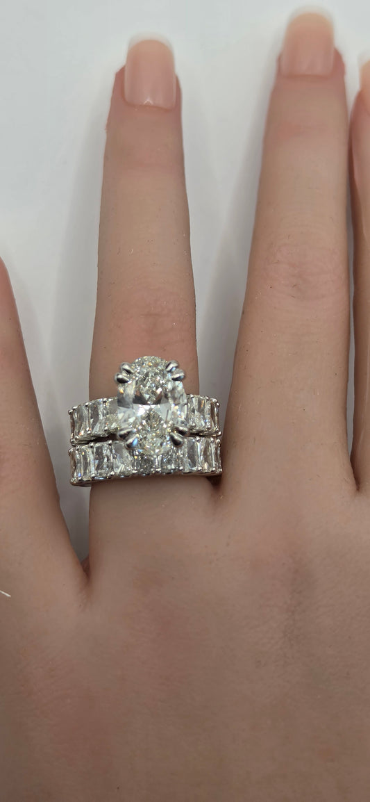 Silver ring with gemstones on a hand against a white background