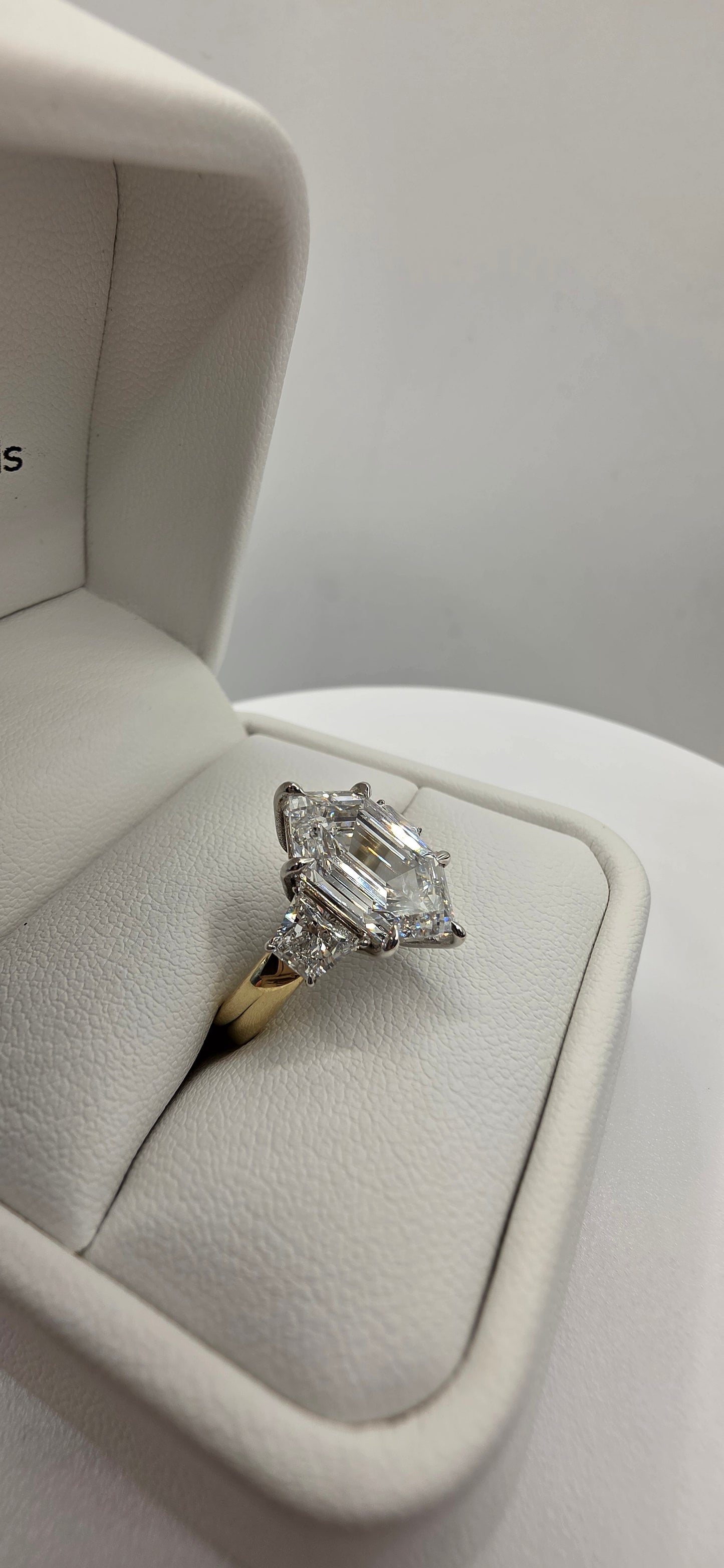 Diamond ring in a jewelry box on a light gray background