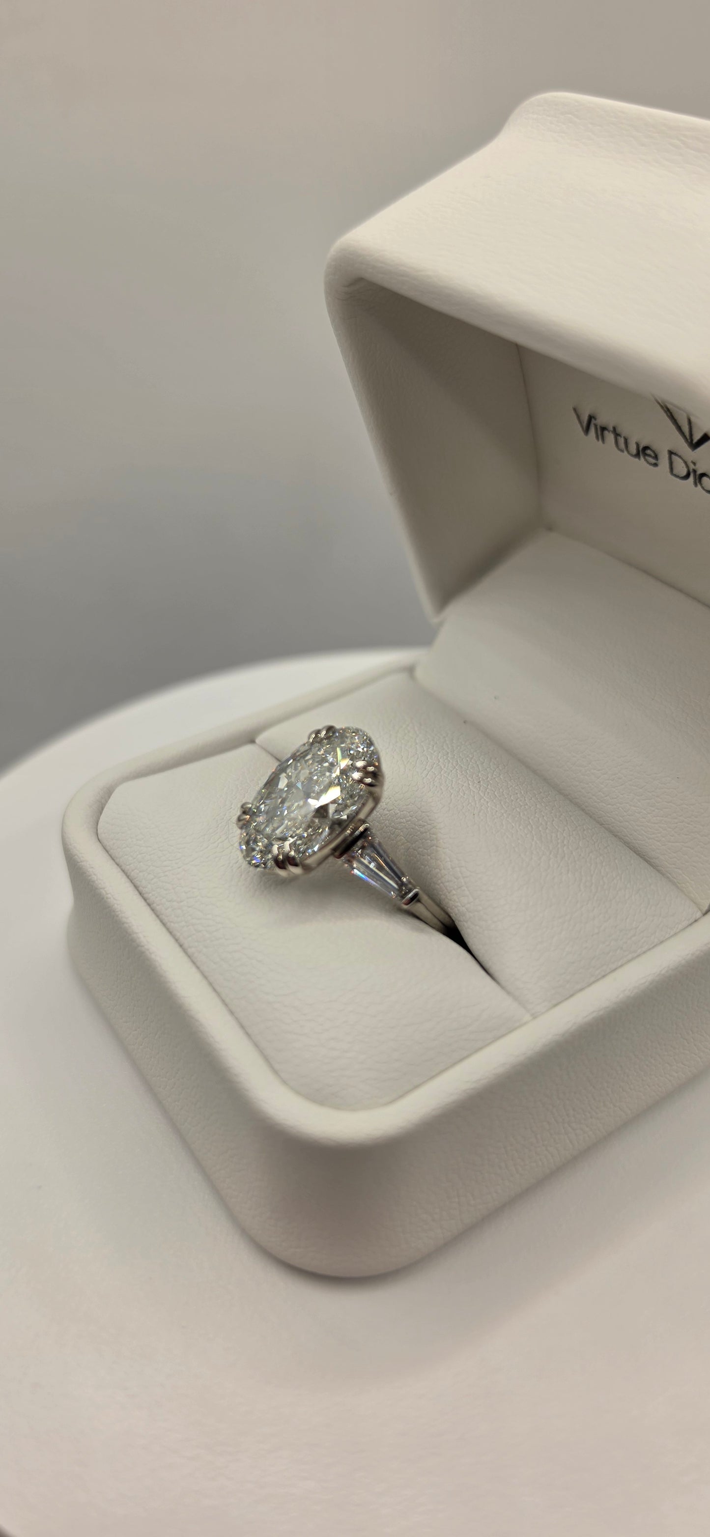 Diamond ring in a white box on a light gray background