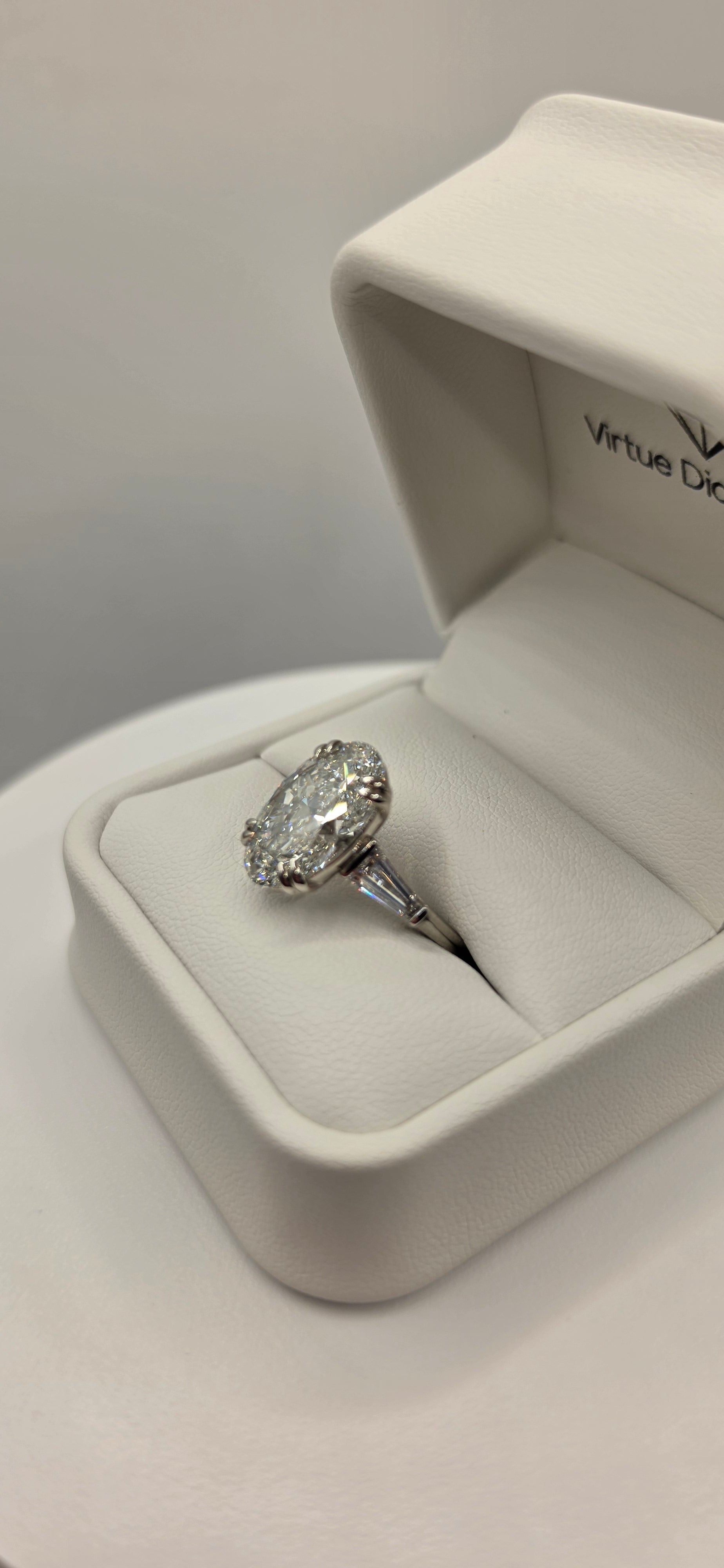 Diamond ring in a white box on a light gray background