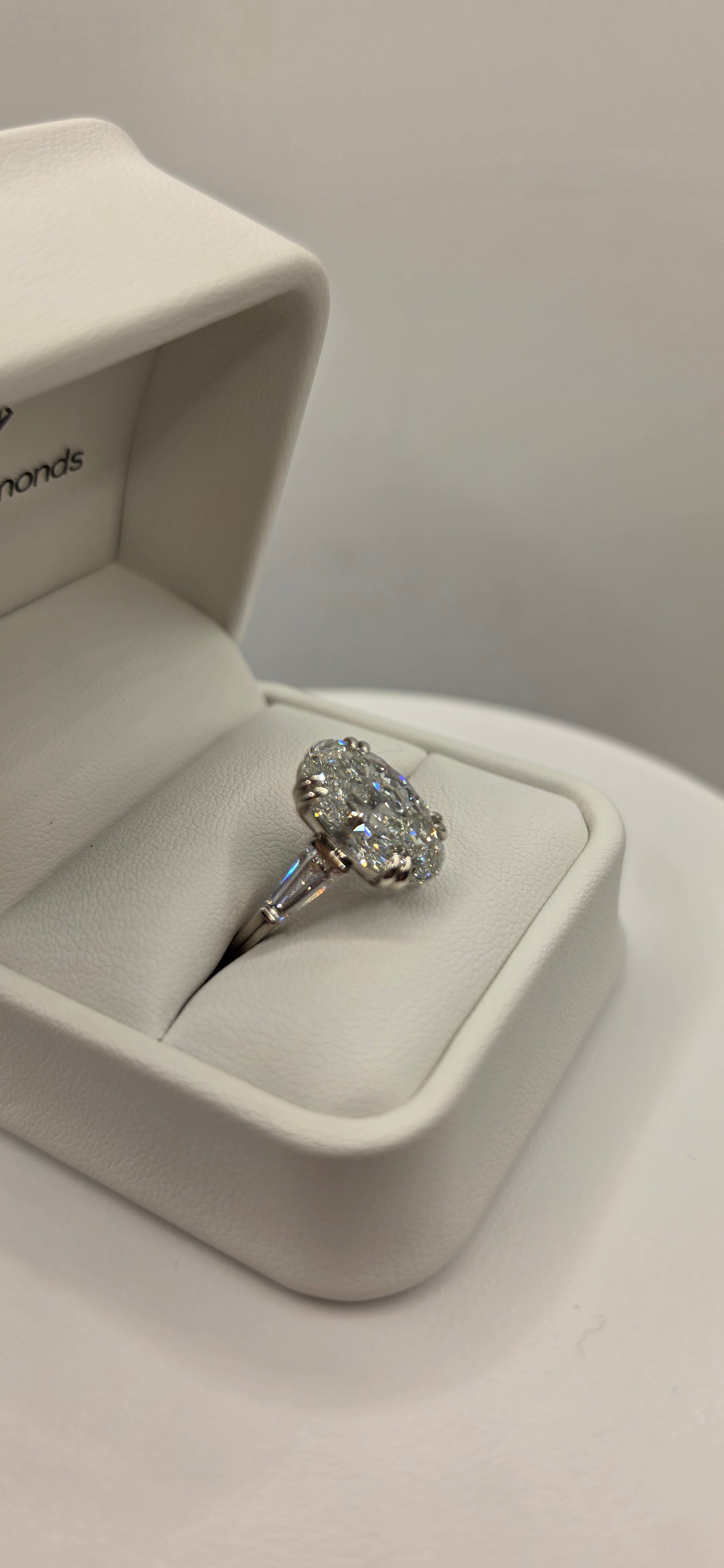 Diamond ring in a white box on a light gray background