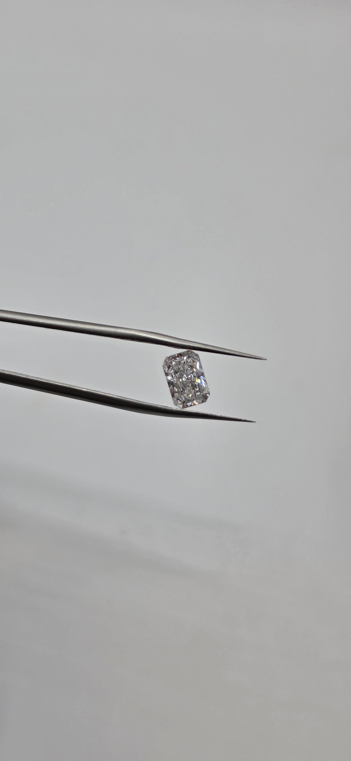 Diamond on a thin metal rod against a gray background
