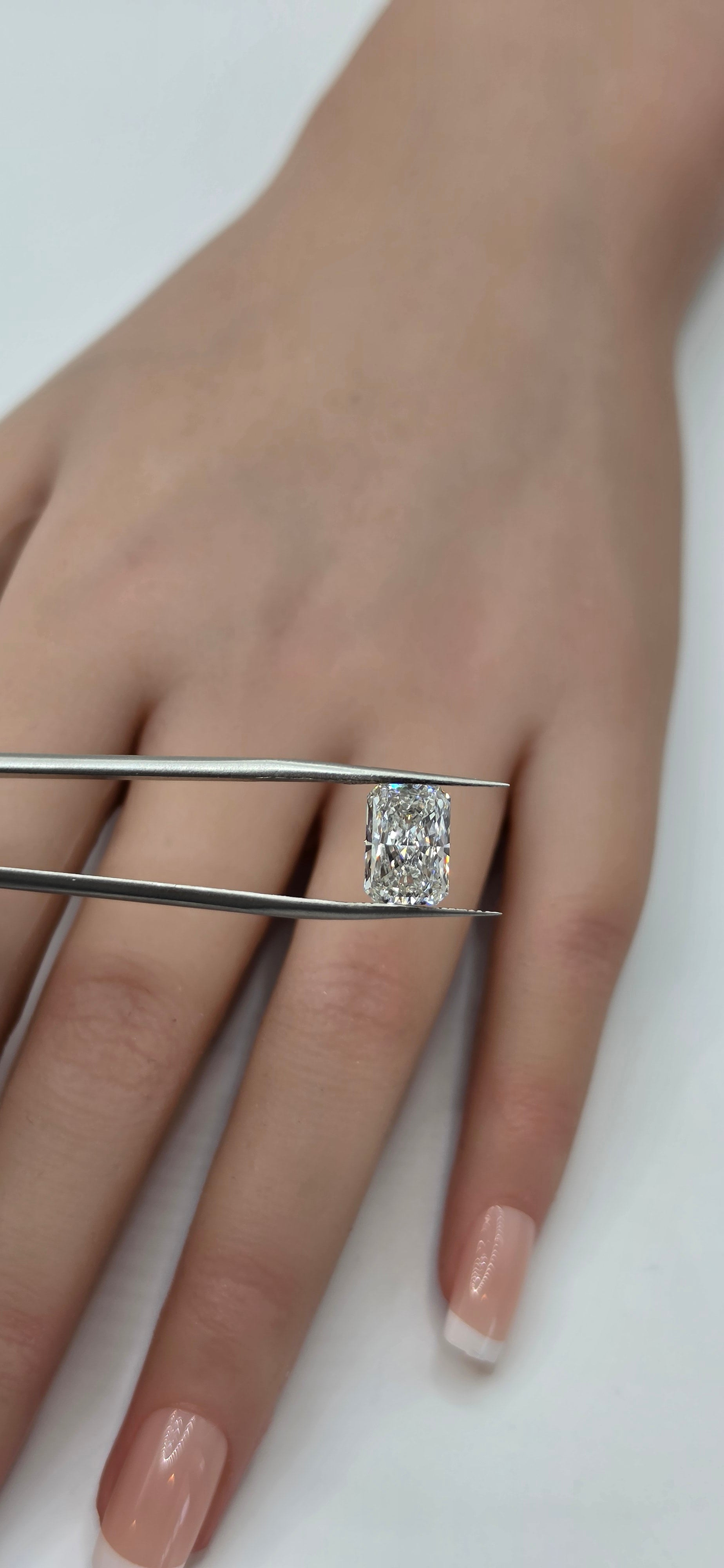 Hand wearing a diamond ring with a white background