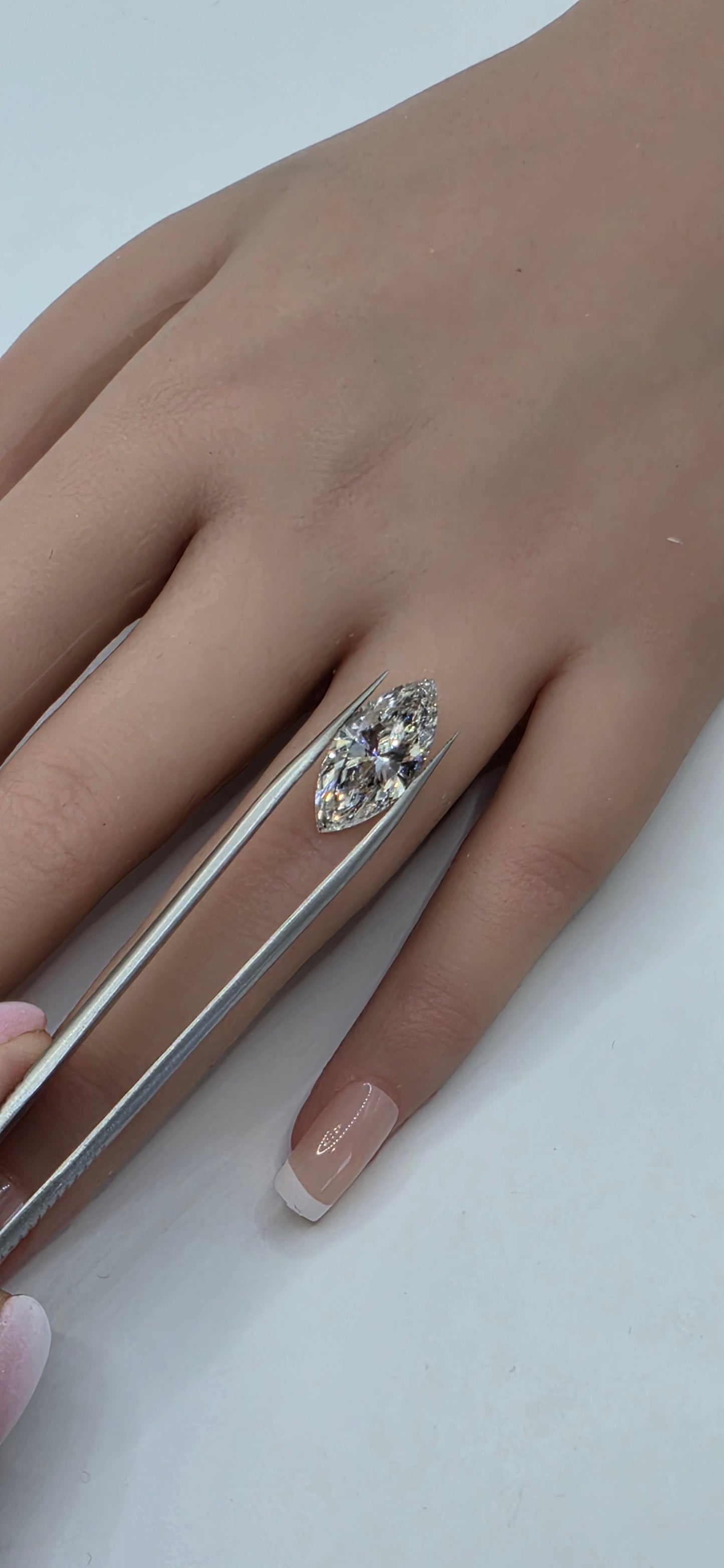Hand wearing a decorative ring on a plain background