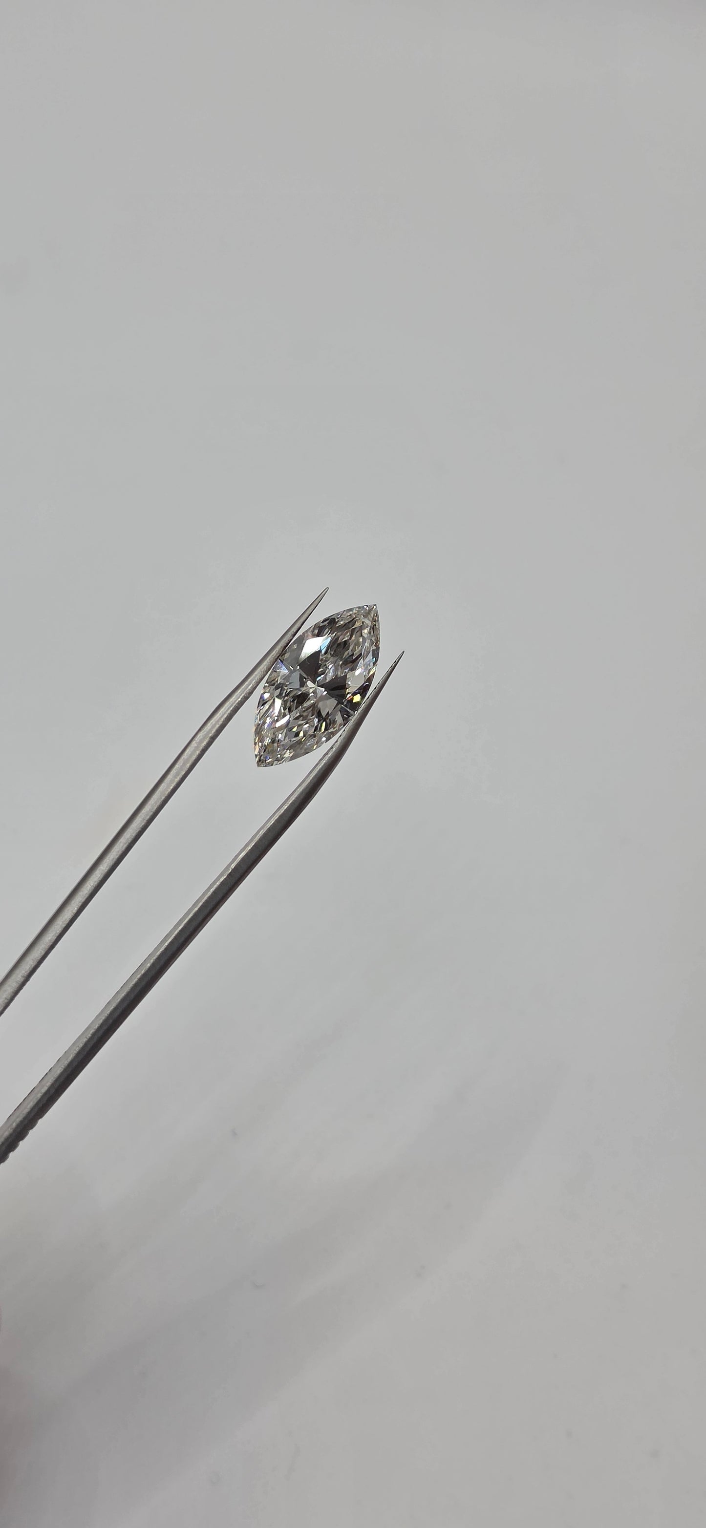 Diamond on a thin metal rod against a light gray background