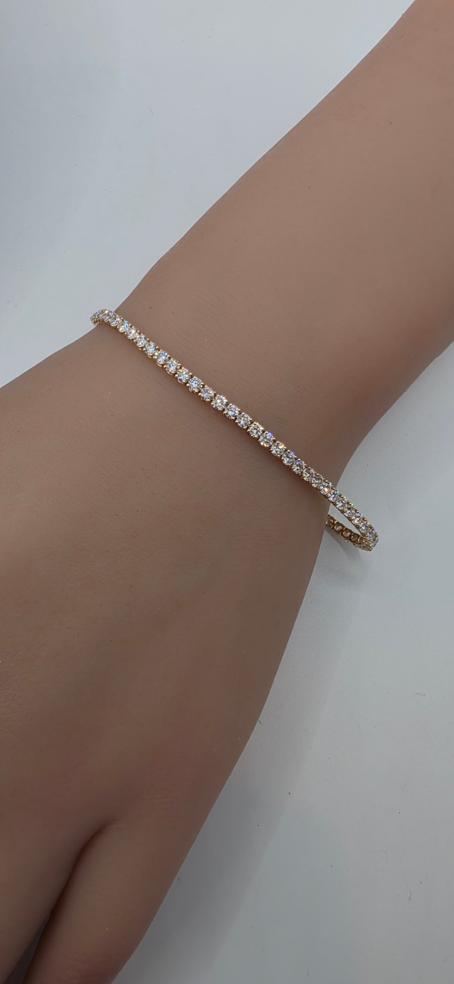 Bracelet with clear stones on a wrist against a white background