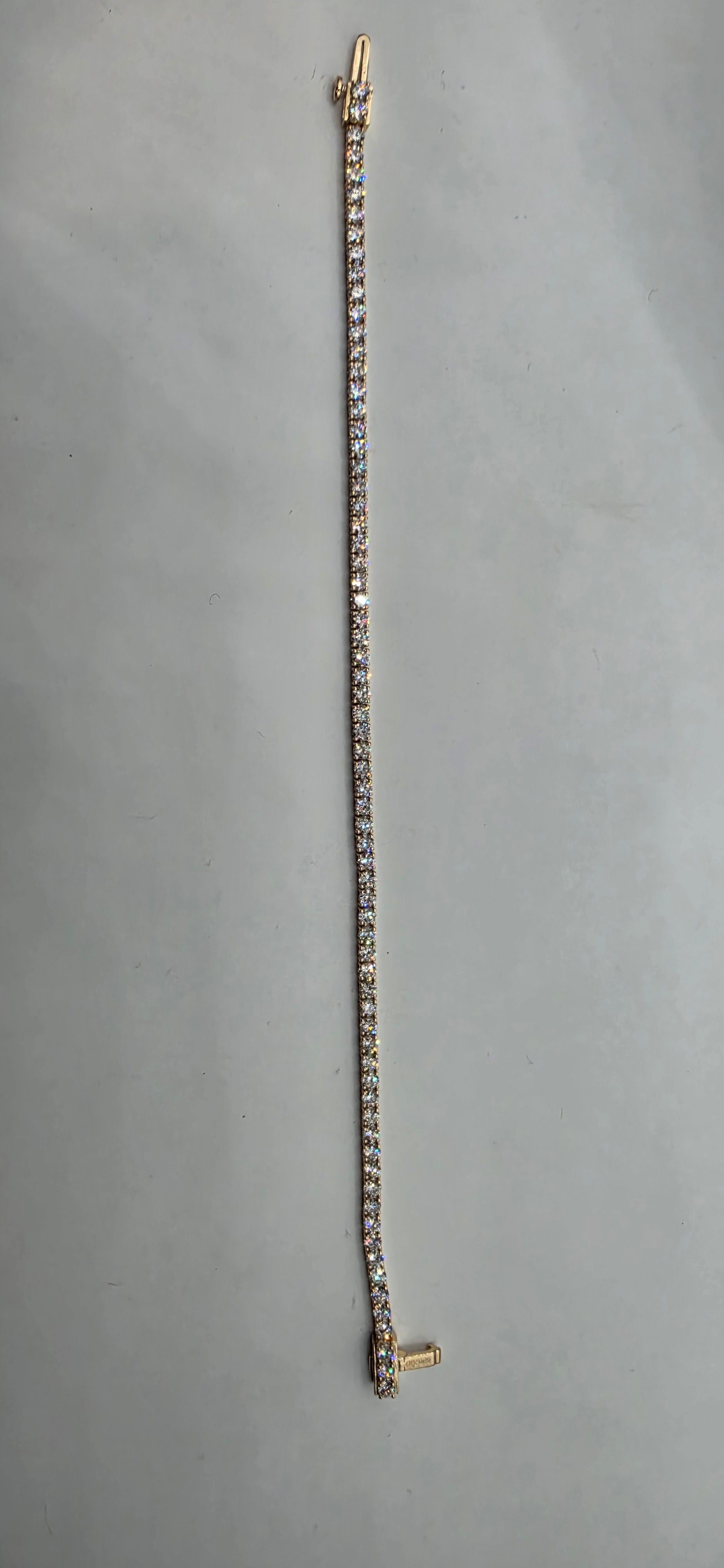 Silver bracelet with gold clasp on a gray background