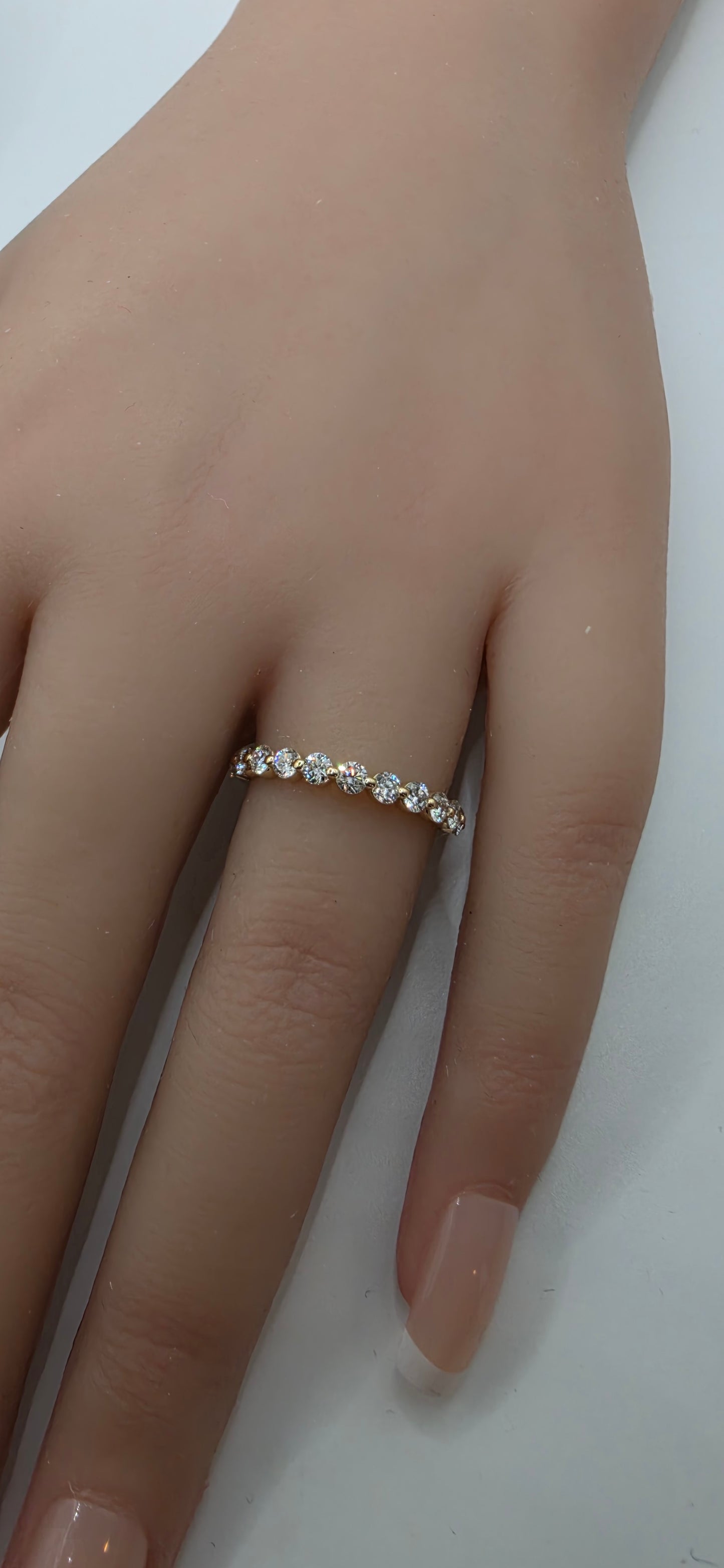 Close-up of a hand wearing a gold ring on a white background