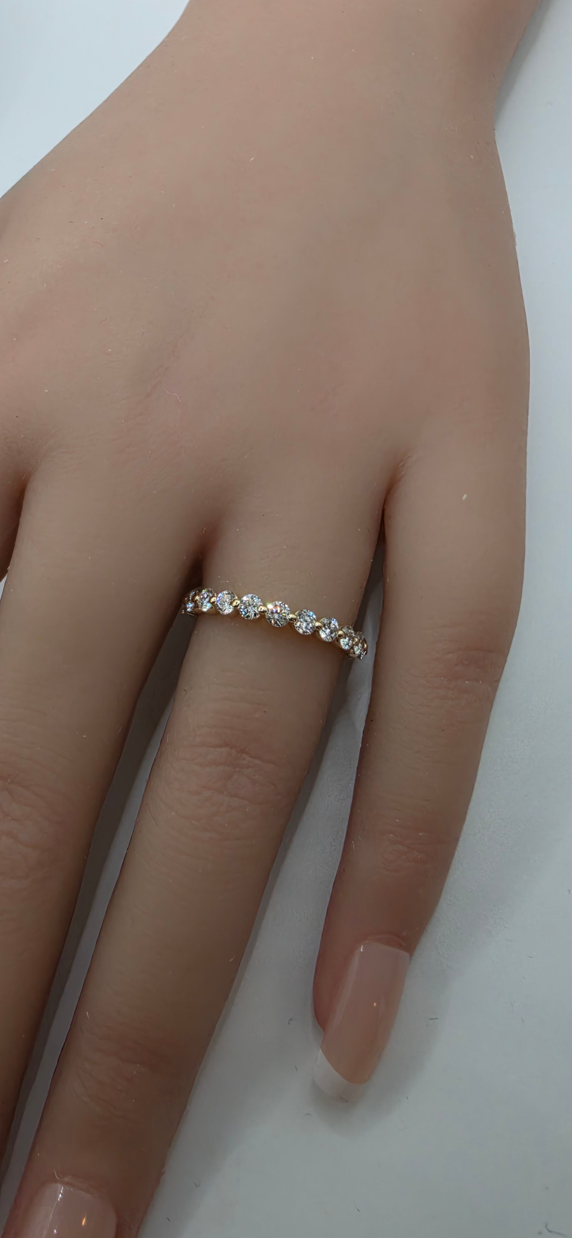 Close-up of a hand wearing a gold ring on a white background