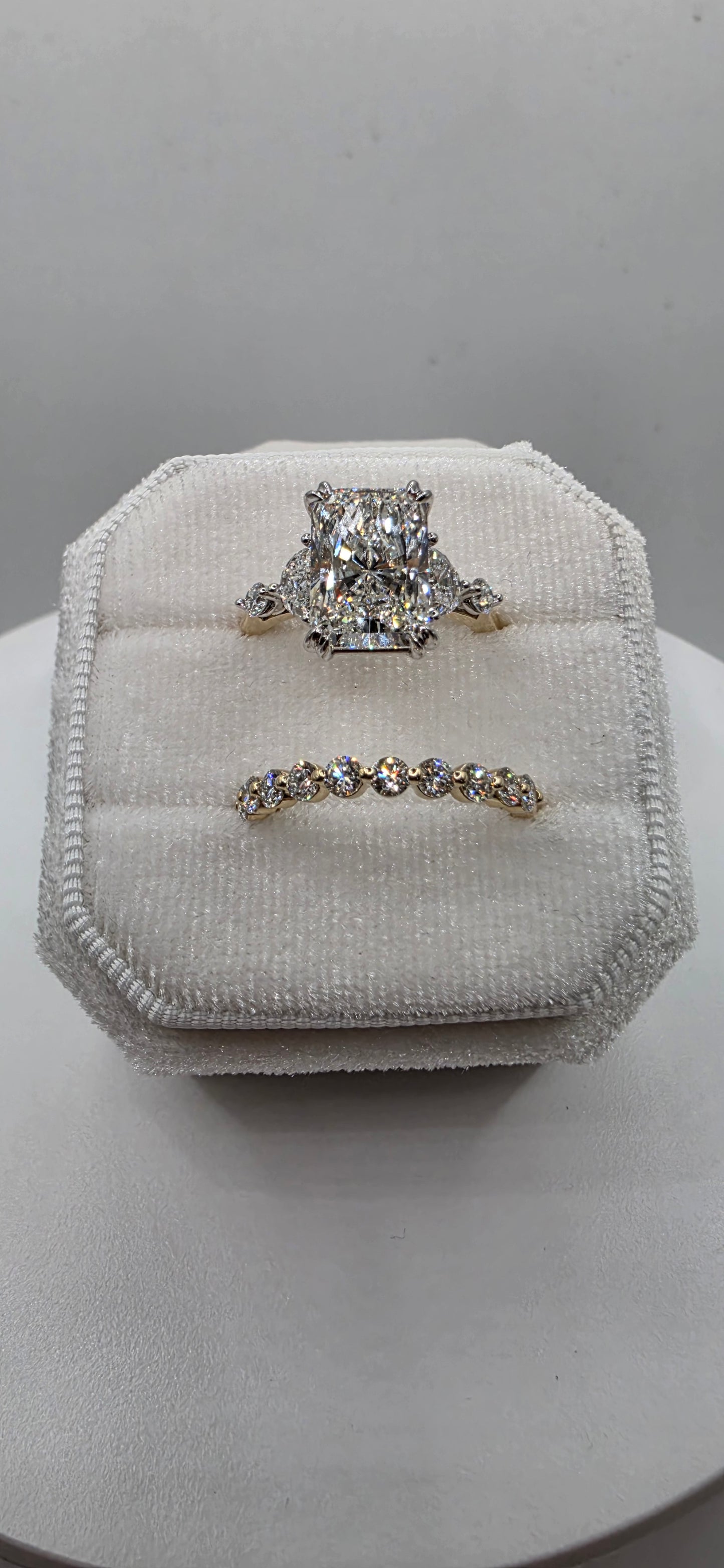 Pair of silver earrings on a white cushioned stand against a neutral background
