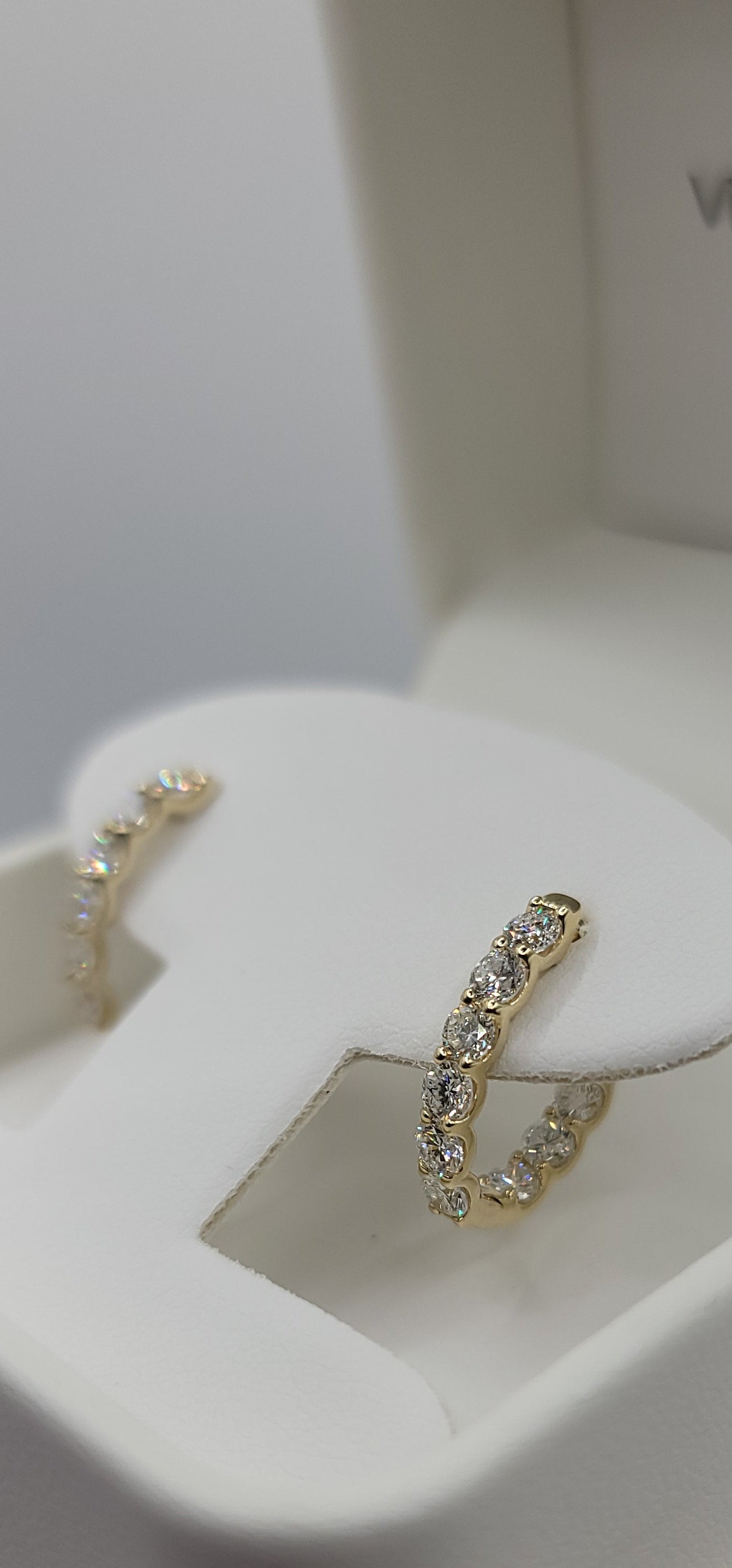 Gold rings on a white jewelry display stand with a blurred background