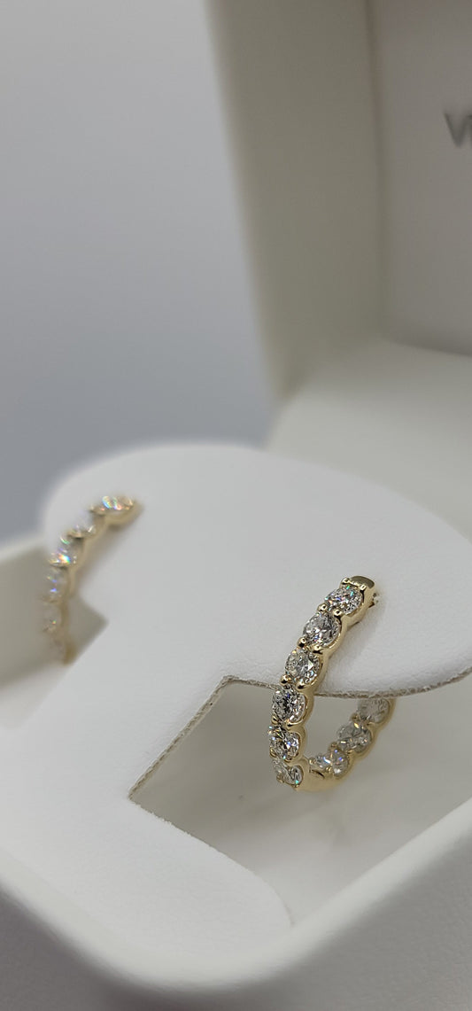Gold rings on a white jewelry display stand with a blurred background