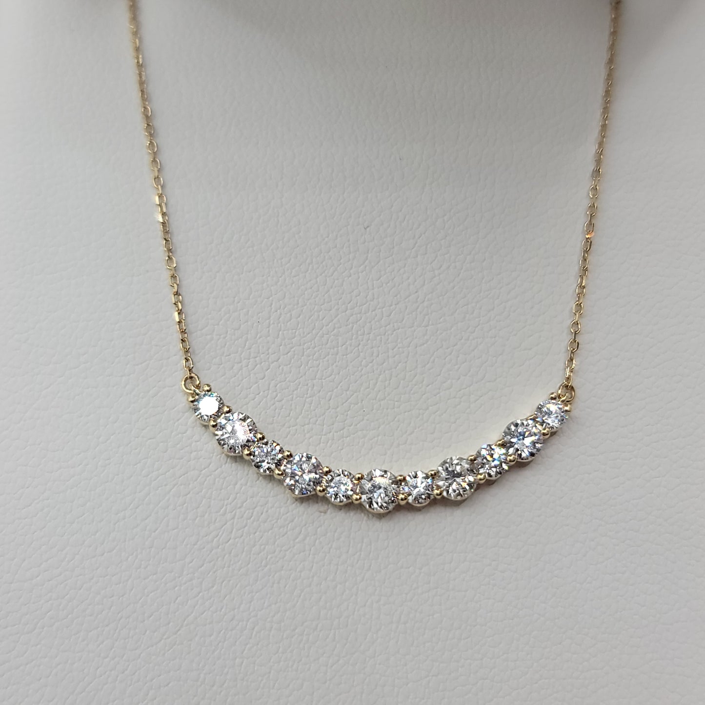 Gold necklace with diamonds on a light gray background