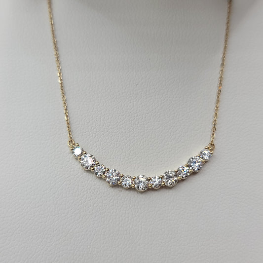 Gold necklace with diamonds on a light gray background