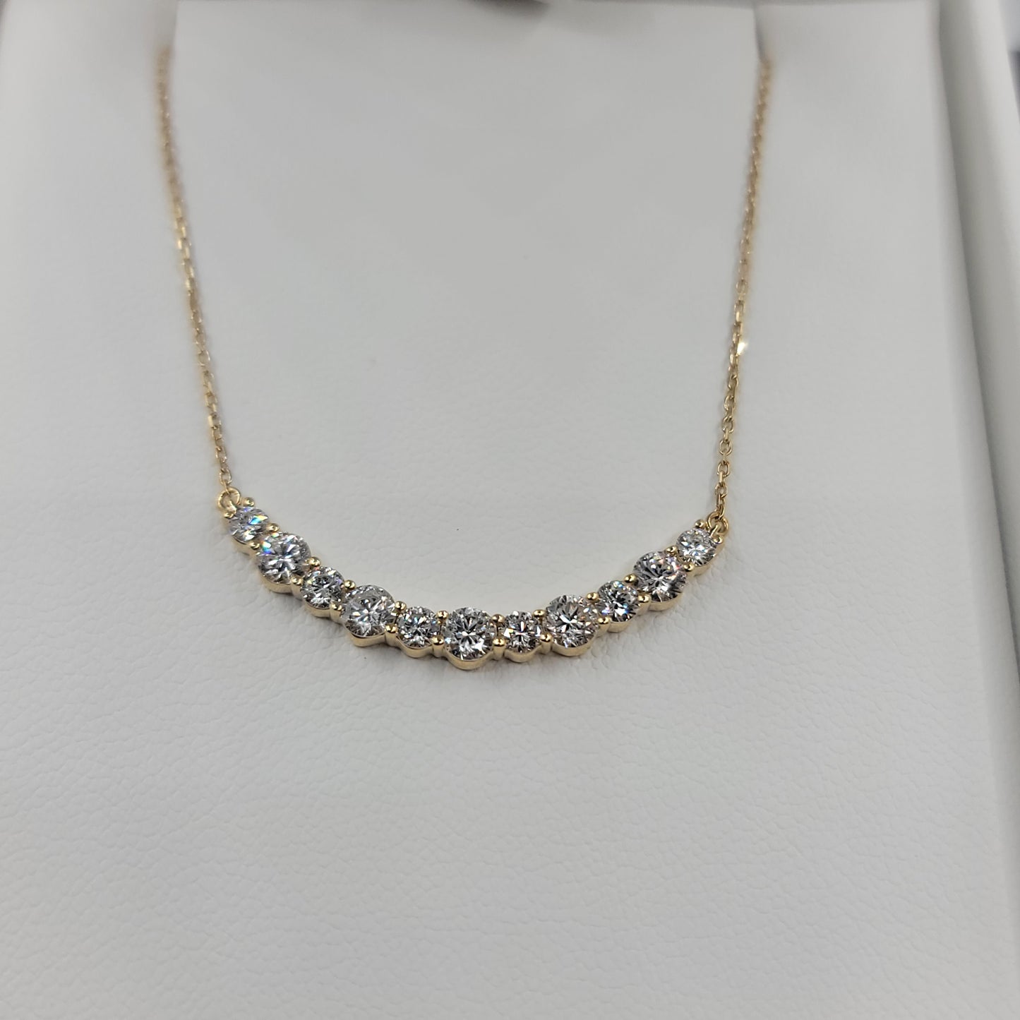 Gold necklace with diamonds on a light gray background
