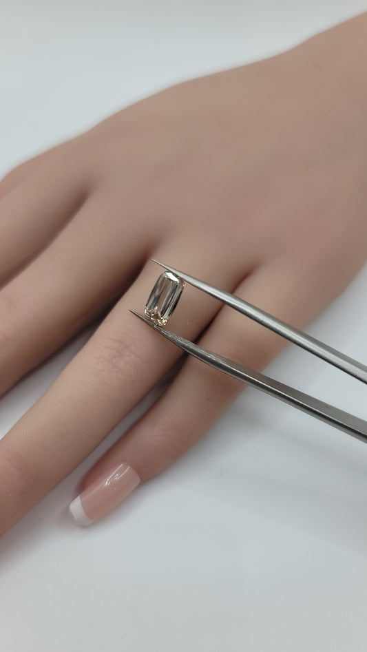Lab grown crisscut diamond held with tweezers against a hand. 