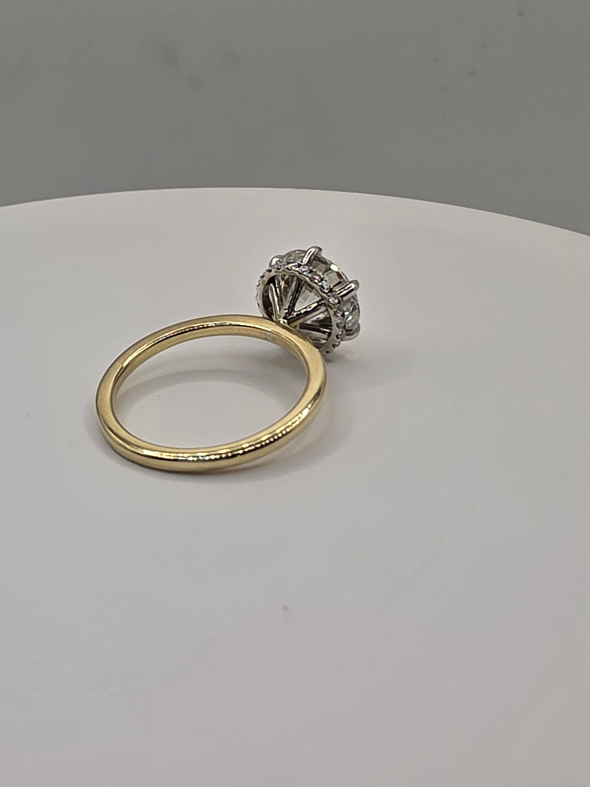 Round diamond ring with yellow gold on a white background